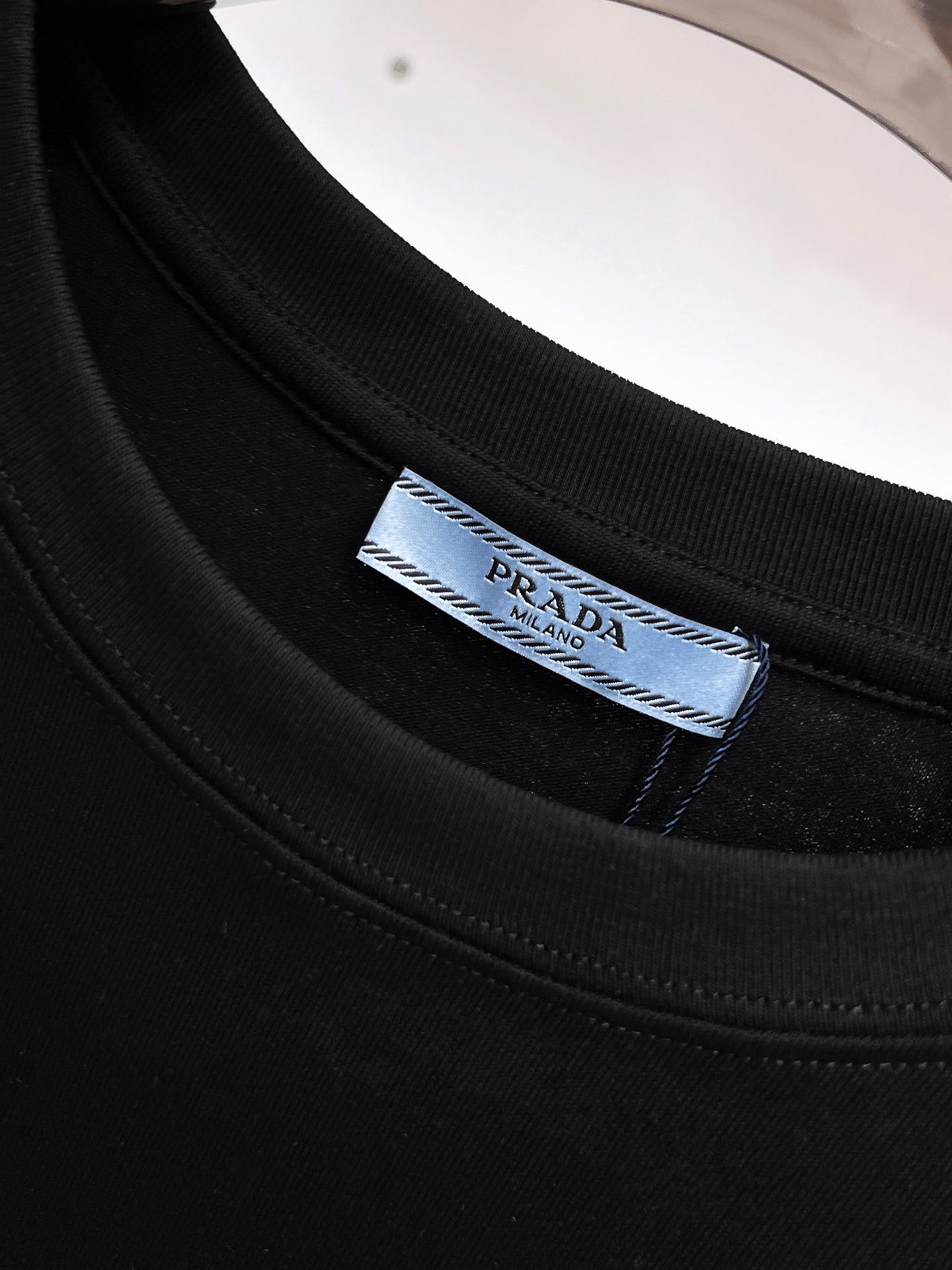 Prada【新品】2026SS春夏🆕 男女情侶款經典logo圖標設計短袖T卹簡約的時尚元素設計凸顯精簡,隸屬今夏高顏值單品. 客供優質針織棉面料,手感順滑細膩,著身的透氣舒適感無可挑剔.全新標誌皮質徽章縫製感染力強大,彰顯前衛獨特個性.時尚達人的必備單品.表達一絲不苟的時尚氣息. 顏色：白色黑色尺碼：S/M/L/XL/2XL S肩寬43胸圍104衣長67袖長21