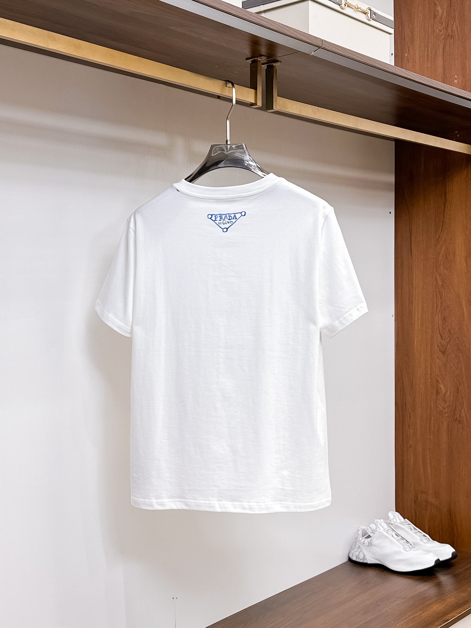 Prada【新品】2026SS春夏🆕 男女情侶款經典logo圖標設計短袖T卹簡約的時尚元素設計凸顯精簡,隸屬今夏高顏值單品. 客供優質針織棉面料,手感順滑細膩,著身的透氣舒適感無可挑剔.全新標誌皮質徽章縫製感染力強大,彰顯前衛獨特個性.時尚達人的必備單品.表達一絲不苟的時尚氣息. 顏色：白色黑色尺碼：S/M/L/XL/2XL S肩寬43胸圍104衣長67袖長21