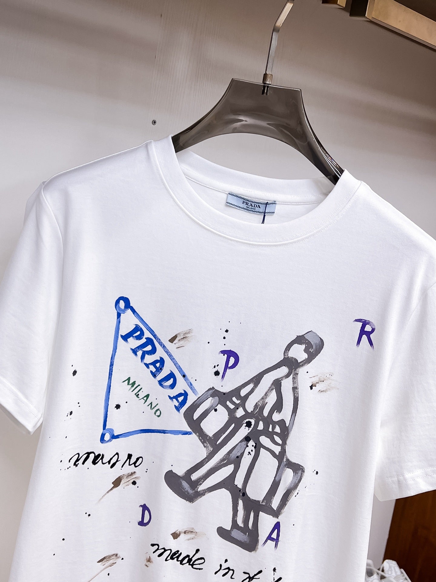 Prada【新品】2026SS春夏🆕 男女情侶款經典logo圖標設計短袖T卹簡約的時尚元素設計凸顯精簡,隸屬今夏高顏值單品. 客供優質針織棉面料,手感順滑細膩,著身的透氣舒適感無可挑剔.全新標誌皮質徽章縫製感染力強大,彰顯前衛獨特個性.時尚達人的必備單品.表達一絲不苟的時尚氣息. 顏色：白色黑色尺碼：S/M/L/XL/2XL S肩寬43胸圍104衣長67袖長21