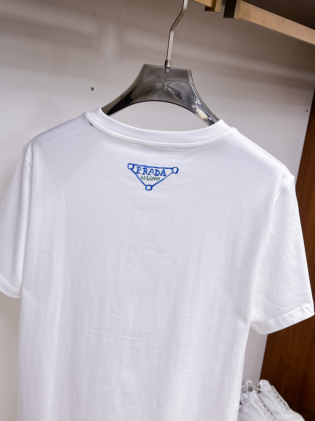 Prada【新品】2026SS春夏🆕 男女情侶款經典logo圖標設計短袖T卹簡約的時尚元素設計凸顯精簡,隸屬今夏高顏值單品. 客供優質針織棉面料,手感順滑細膩,著身的透氣舒適感無可挑剔.全新標誌皮質徽章縫製感染力強大,彰顯前衛獨特個性.時尚達人的必備單品.表達一絲不苟的時尚氣息. 顏色：白色黑色尺碼：S/M/L/XL/2XL S肩寬43胸圍104衣長67袖長21