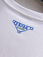 Prada【新品】2026SS春夏🆕 男女情侶款經典logo圖標設計短袖T卹簡約的時尚元素設計凸顯精簡,隸屬今夏高顏值單品. 客供優質針織棉面料,手感順滑細膩,著身的透氣舒適感無可挑剔.全新標誌皮質徽章縫製感染力強大,彰顯前衛獨特個性.時尚達人的必備單品.表達一絲不苟的時尚氣息. 顏色：白色黑色尺碼：S/M/L/XL/2XL S肩寬43胸圍104衣長67袖長21
