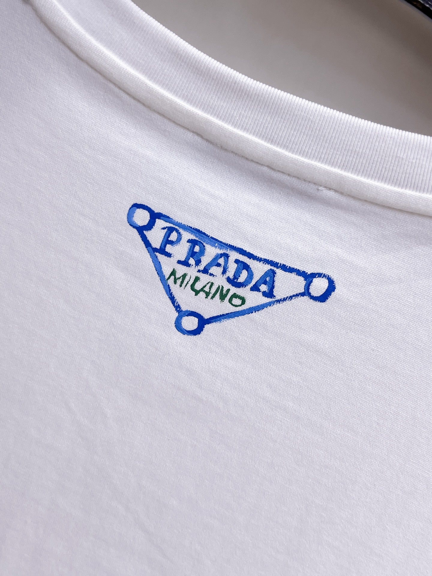 Prada【新品】2026SS春夏🆕 男女情侶款經典logo圖標設計短袖T卹簡約的時尚元素設計凸顯精簡,隸屬今夏高顏值單品. 客供優質針織棉面料,手感順滑細膩,著身的透氣舒適感無可挑剔.全新標誌皮質徽章縫製感染力強大,彰顯前衛獨特個性.時尚達人的必備單品.表達一絲不苟的時尚氣息. 顏色：白色黑色尺碼：S/M/L/XL/2XL S肩寬43胸圍104衣長67袖長21