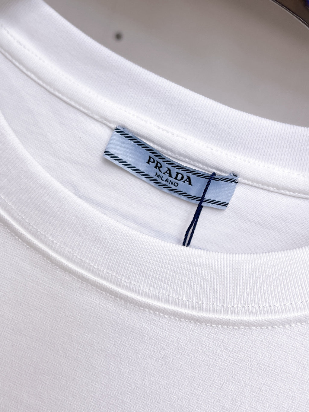 Prada【新品】2026SS春夏🆕 男女情侶款經典logo圖標設計短袖T卹簡約的時尚元素設計凸顯精簡,隸屬今夏高顏值單品. 客供優質針織棉面料,手感順滑細膩,著身的透氣舒適感無可挑剔.全新標誌皮質徽章縫製感染力強大,彰顯前衛獨特個性.時尚達人的必備單品.表達一絲不苟的時尚氣息. 顏色：白色黑色尺碼：S/M/L/XL/2XL S肩寬43胸圍104衣長67袖長21