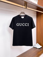 古馳【新品】2026SS春夏🆕 男女情侶款經典圖標設計短袖T卹簡約的時尚元素設計凸顯精簡,隸屬今夏高顏值單品. 客供優質針織棉面料,手感順滑細膩,著身的透氣舒適感無可挑剔.搭配時尚廓形裁剪設計精美設計.全新標誌皮質徽章縫製感染力強大,彰顯前衛獨特個性.時尚達人的必備單品.表達一絲不苟的時尚氣息. 顏色：黑色，白色尺碼：S/M/L/XL/2XL S肩寬43胸圍104衣長67袖長2