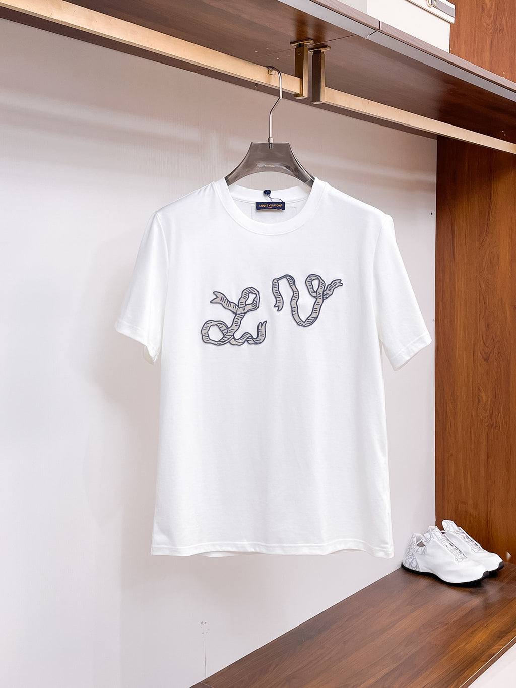 路易【新品】2026SS春夏🆕 男女情侶款經典圖標設計短袖T卹簡約的時尚元素設計凸顯精簡,隸屬今夏高顏值單品. 客供優質針織棉面料,手感順滑細膩,著身的透氣舒適感無可挑剔.搭配時尚廓形裁剪設計精美設計.全新標誌皮質徽章縫製感染力強大,彰顯前衛獨特個性.時尚達人的必備單品.表達一絲不苟的時尚氣息. 顏色：黑色，白色尺碼：S/M/L/XL/2XL S肩寬43胸圍104衣長67袖長21