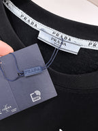 普拉達【新品】2026SS春夏🆕 男女情侶款經典圖標設計短袖T卹簡約的時尚元素設計凸顯精簡,隸屬今夏高顏值單品. 客供優質針織棉面料,手感順滑細膩,著身的透氣舒適感無可挑剔.搭配時尚廓形裁剪設計設計精美設計採用潮流時尚的透氣舒適感.全新標誌皮質徽章縫製感染力強大,彰顯前衛獨特個性.時尚達人的必備單品.表達一絲不苟的時尚氣息. 顏色：黑色，白色尺碼：S/M/L/XL/2XL S肩寬43胸圍104衣長67袖長21