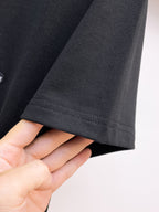 古馳【新品】2026SS春夏🆕 男女情侶款經典圖標設計短袖T卹簡約的時尚元素設計凸顯精簡,隸屬今夏高顏值單品. 客供優質針織棉面料,手感順滑細膩,著身的透氣舒適感無可挑剔.搭配時尚廓形裁剪設計精美設計.全新標誌皮質徽章縫製感染力強大,彰顯前衛獨特個性.時尚達人的必備單品.表達一絲不苟的時尚氣息. 顏色：黑色，白色尺碼：S/M/L/XL/2XL S肩寬43胸圍104衣長67袖長21