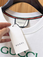Gucci【新品】2026SS春夏🆕 男女情侶款經典logo圖標設計短袖T卹簡約的時尚元素設計凸顯精簡,隸屬今夏高顏值單品. 客供優質針織棉面料,手感順滑細膩,著身的透氣舒適感無可挑剔.全新標誌皮質徽章縫製感染力強大,彰顯前衛獨特個性.時尚達人的必備單品.表達一絲不苟的時尚氣息. 顏色：白色黑色尺碼：S/M/L/XL/2XL S肩寬43胸圍104衣長67袖長21