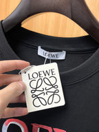 Loewe 【新品】2026SS春夏🆕 男女情侶款經典logo圖標設計短袖T卹簡約的時尚元素設計凸顯精簡,隸屬今夏高顏值單品. 客供優質針織棉面料,手感順滑細膩,著身的透氣舒適感無可挑剔.顯風時尚.全新標誌皮質徽章縫製感染力強大,彰顯前衛獨特個性.時尚達人的必備單品.表達一絲不苟的時尚氣息. 顏色：白色黑色尺碼：S/M/L/XL/2XL S肩寬43胸圍104衣長67袖長21
