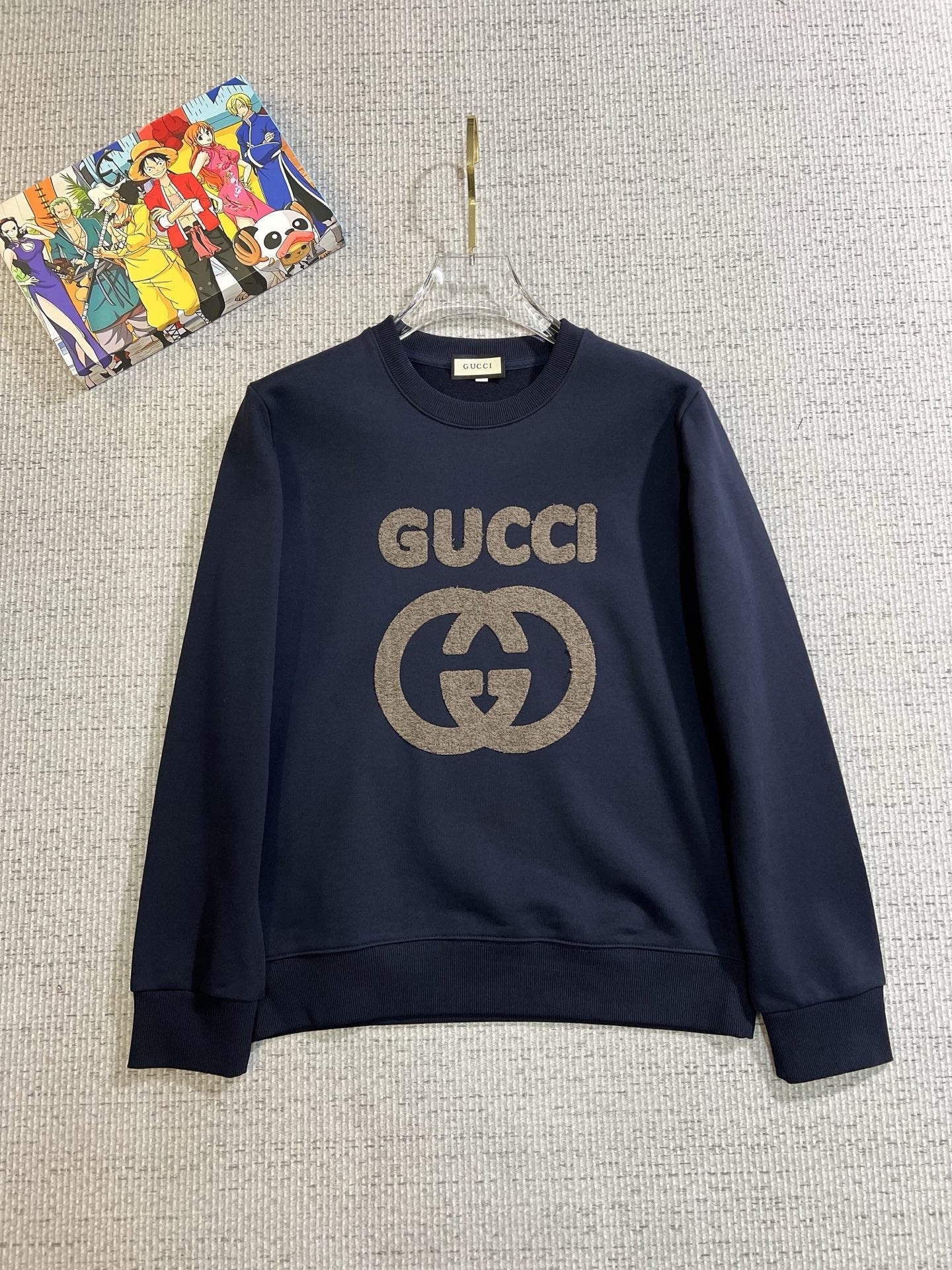 GUCCI 古奇2025秋冬新款設計感衛衣官網同步！這款T卹極簡主義設計和精美細節於一身。 Oversize飾邊引人聯想蒂羅爾著裝細節，召喚摩登新意，造就不同以往的概念化圖案，為傳統棉質T卹注入豐盈內涵。前幅圖形織帶車出的LOGO，別具一番特色，更顯品牌尊貴彰顯大牌風範，襯託出了極簡主義的設計風格，把優雅風展露的一覽無餘！ 作為一個追求設計感和裁剪工藝的品牌，用料永遠不會讓人失望！這款衫身採用索洛納棉混紡400 克布料，高貴精緻，布面棉質飽滿柔軟親膚總之這麼經典的款，秋冬必備！ M-4XL