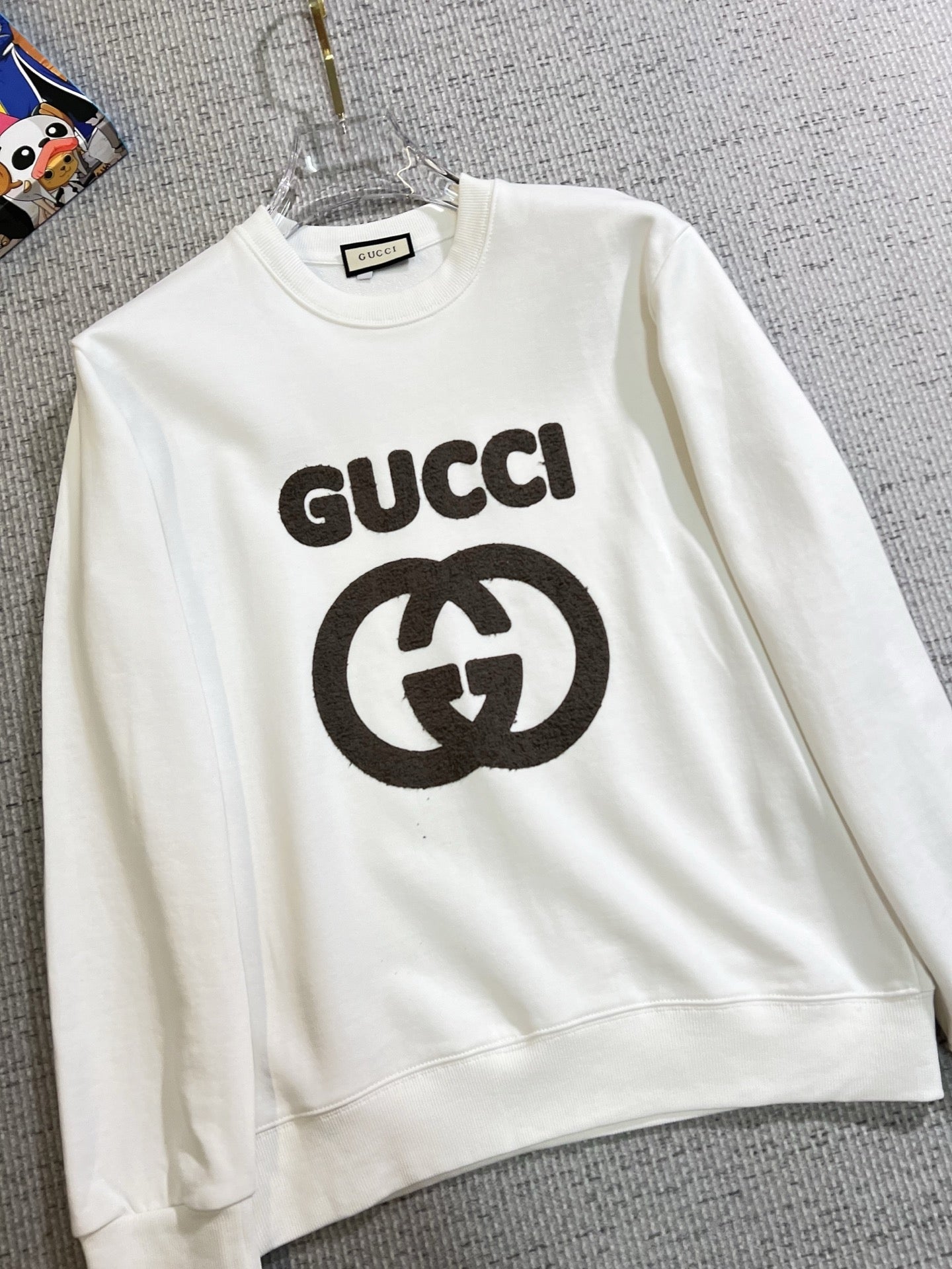 GUCCI 古奇2025秋冬新款設計感衛衣官網同步！這款T卹極簡主義設計和精美細節於一身。 Oversize飾邊引人聯想蒂羅爾著裝細節，召喚摩登新意，造就不同以往的概念化圖案，為傳統棉質T卹注入豐盈內涵。前幅圖形織帶車出的LOGO，別具一番特色，更顯品牌尊貴彰顯大牌風範，襯託出了極簡主義的設計風格，把優雅風展露的一覽無餘！ 作為一個追求設計感和裁剪工藝的品牌，用料永遠不會讓人失望！這款衫身採用索洛納棉混紡400 克布料，高貴精緻，布面棉質飽滿柔軟親膚總之這麼經典的款，秋冬必備！ M-4XL