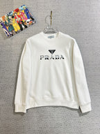 PRADA 普拉達2025秋冬新款設計感衛衣官網同步！這款T卹極簡主義設計和精美細節於一身。 Oversize飾邊引人聯想蒂羅爾著裝細節，召喚摩登新意，造就不同以往的概念化圖案，為傳統棉質T卹注入豐盈內涵。前幅圖形織帶車出的LOGO，別具一番特色，更顯品牌尊貴彰顯大牌風範，襯託出了極簡主義的設計風格，把優雅風展露的一覽無餘！ 作為一個追求設計感和裁剪工藝的品牌，用料永遠不會讓人失望！這款衫身採用索洛納棉混紡400 克布料，高貴精緻，布面棉質飽滿柔軟親膚總之這麼經典的款，秋冬必備！ M-4XL