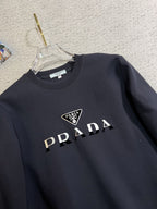 PRADA 普拉達2025秋冬新款設計感衛衣官網同步！這款T卹極簡主義設計和精美細節於一身。 Oversize飾邊引人聯想蒂羅爾著裝細節，召喚摩登新意，造就不同以往的概念化圖案，為傳統棉質T卹注入豐盈內涵。前幅圖形織帶車出的LOGO，別具一番特色，更顯品牌尊貴彰顯大牌風範，襯託出了極簡主義的設計風格，把優雅風展露的一覽無餘！ 作為一個追求設計感和裁剪工藝的品牌，用料永遠不會讓人失望！這款衫身採用索洛納棉混紡400 克布料，高貴精緻，布面棉質飽滿柔軟親膚總之這麼經典的款，秋冬必備！ M-4XL