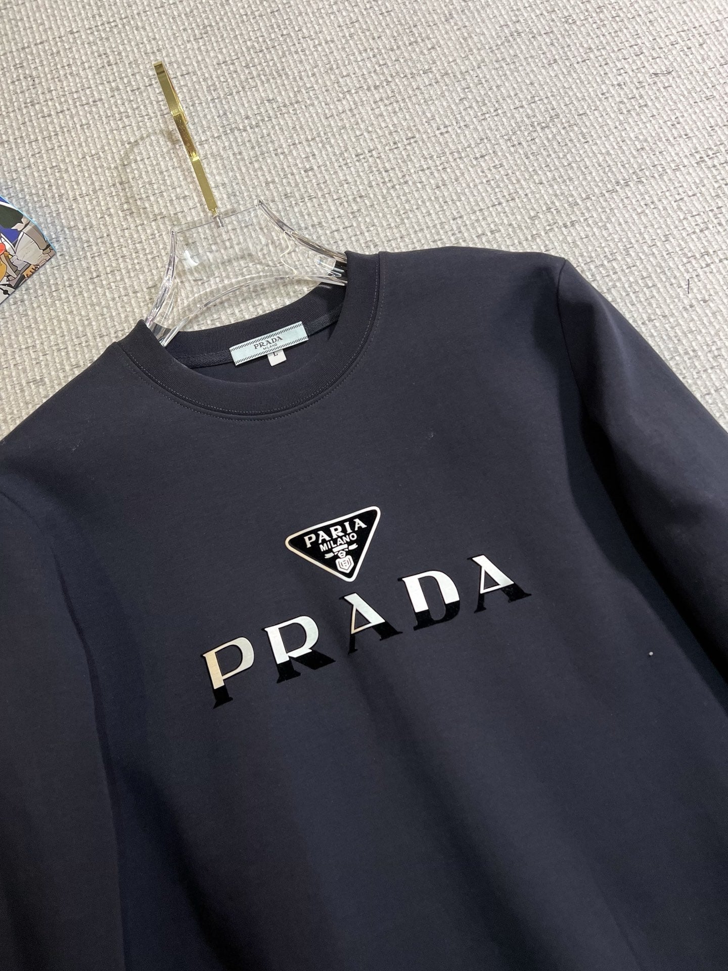 PRADA 普拉達2025秋冬新款設計感衛衣官網同步！這款T卹極簡主義設計和精美細節於一身。 Oversize飾邊引人聯想蒂羅爾著裝細節，召喚摩登新意，造就不同以往的概念化圖案，為傳統棉質T卹注入豐盈內涵。前幅圖形織帶車出的LOGO，別具一番特色，更顯品牌尊貴彰顯大牌風範，襯託出了極簡主義的設計風格，把優雅風展露的一覽無餘！ 作為一個追求設計感和裁剪工藝的品牌，用料永遠不會讓人失望！這款衫身採用索洛納棉混紡400 克布料，高貴精緻，布面棉質飽滿柔軟親膚總之這麼經典的款，秋冬必備！ M-4XL