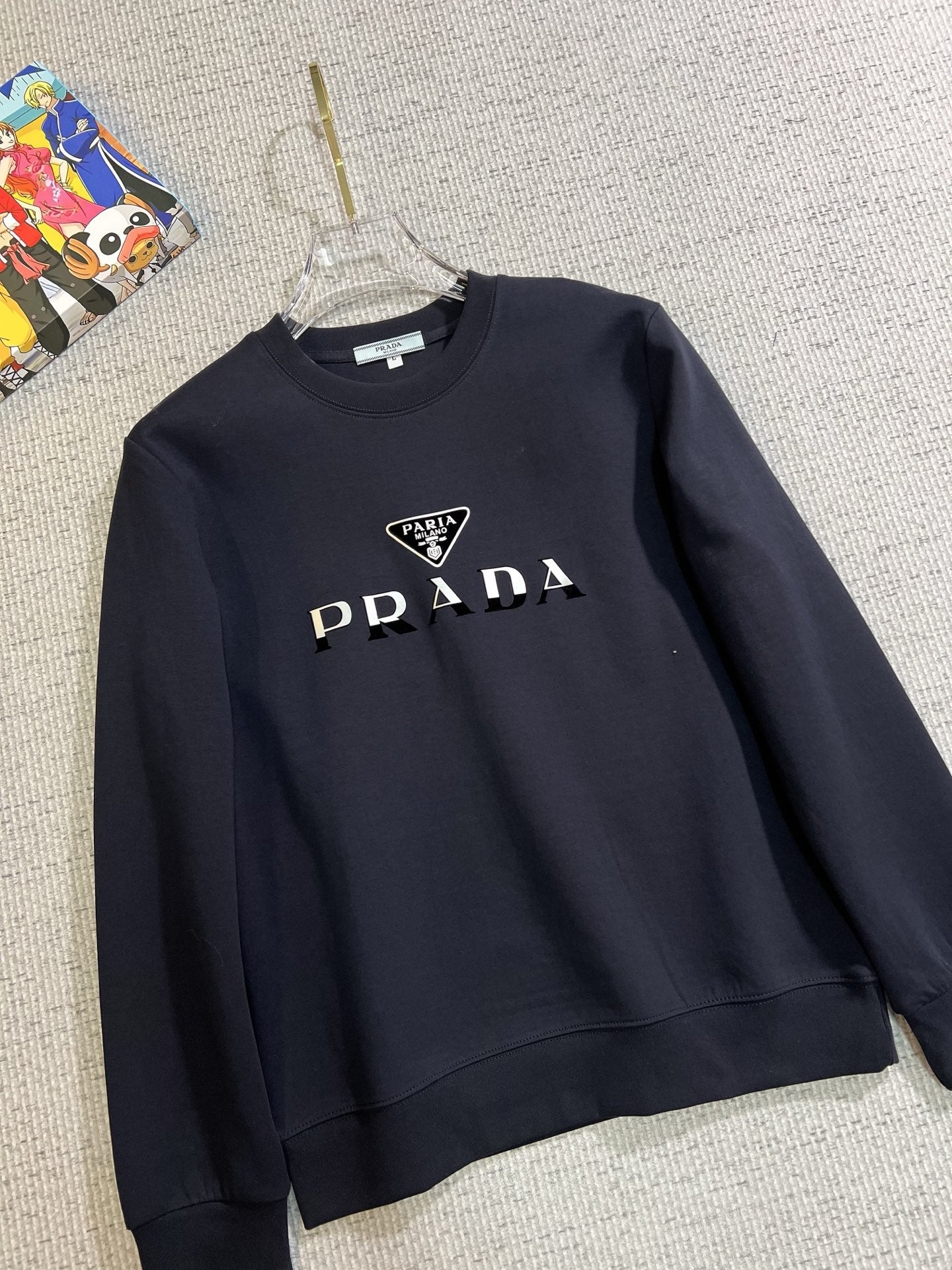PRADA 普拉達2025秋冬新款設計感衛衣官網同步！這款T卹極簡主義設計和精美細節於一身。 Oversize飾邊引人聯想蒂羅爾著裝細節，召喚摩登新意，造就不同以往的概念化圖案，為傳統棉質T卹注入豐盈內涵。前幅圖形織帶車出的LOGO，別具一番特色，更顯品牌尊貴彰顯大牌風範，襯託出了極簡主義的設計風格，把優雅風展露的一覽無餘！ 作為一個追求設計感和裁剪工藝的品牌，用料永遠不會讓人失望！這款衫身採用索洛納棉混紡400 克布料，高貴精緻，布面棉質飽滿柔軟親膚總之這麼經典的款，秋冬必備！ M-4XL
