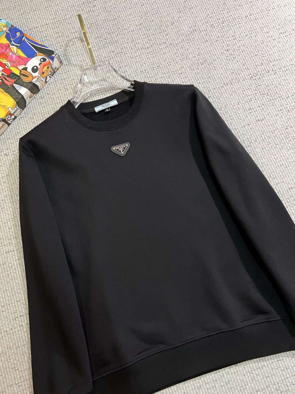 PRADA 普拉達2025秋冬新款設計感衛衣官網同步！這款T卹極簡主義設計和精美細節於一身。 Oversize飾邊引人聯想蒂羅爾著裝細節，召喚摩登新意，造就不同以往的概念化圖案，為傳統棉質T卹注入豐盈內涵。前幅圖形織帶車出的LOGO，別具一番特色，更顯品牌尊貴彰顯大牌風範，襯託出了極簡主義的設計風格，把優雅風展露的一覽無餘！ 作為一個追求設計感和裁剪工藝的品牌，用料永遠不會讓人失望！這款衫身採用索洛納棉混紡400 克布料，高貴精緻，布面棉質飽滿柔軟親膚總之這麼經典的款，秋冬必備！ M-4XL