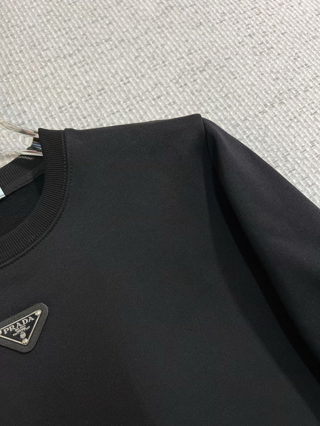 PRADA 普拉達2025秋冬新款設計感衛衣官網同步！這款T卹極簡主義設計和精美細節於一身。 Oversize飾邊引人聯想蒂羅爾著裝細節，召喚摩登新意，造就不同以往的概念化圖案，為傳統棉質T卹注入豐盈內涵。前幅圖形織帶車出的LOGO，別具一番特色，更顯品牌尊貴彰顯大牌風範，襯託出了極簡主義的設計風格，把優雅風展露的一覽無餘！ 作為一個追求設計感和裁剪工藝的品牌，用料永遠不會讓人失望！這款衫身採用索洛納棉混紡400 克布料，高貴精緻，布面棉質飽滿柔軟親膚總之這麼經典的款，秋冬必備！ M-4XL