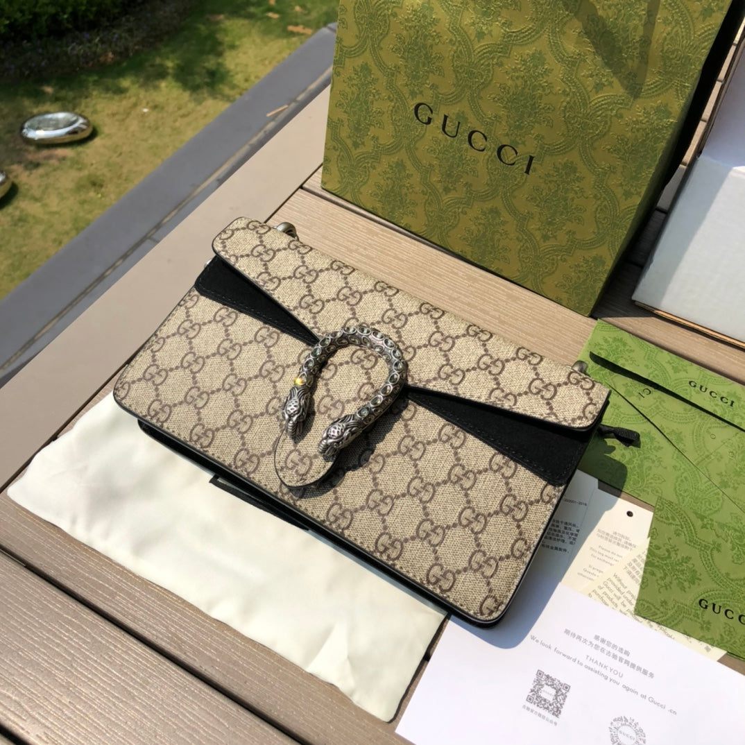 （571150898）尺寸：25×13.5×7cm GUCCI海外渠道資源特供酒神❗️這款Dionysus系列小號肩背包飾有經典GG Supreme帆布環保材料，雙G圖案和絨面材質滾邊細節。包上精心點綴品牌標誌性的飾水晶虎頭搭扣元素，其靈感源自希臘酒神狄俄尼索斯，在神話傳說中，他身騎宙斯派來的老虎跨越底格里斯河，閃亮水晶裝飾令搭扣更顯奢華氣息。滑動鍊帶打造多樣化的背法，可在肩背、斜背和手提之間自由轉換。