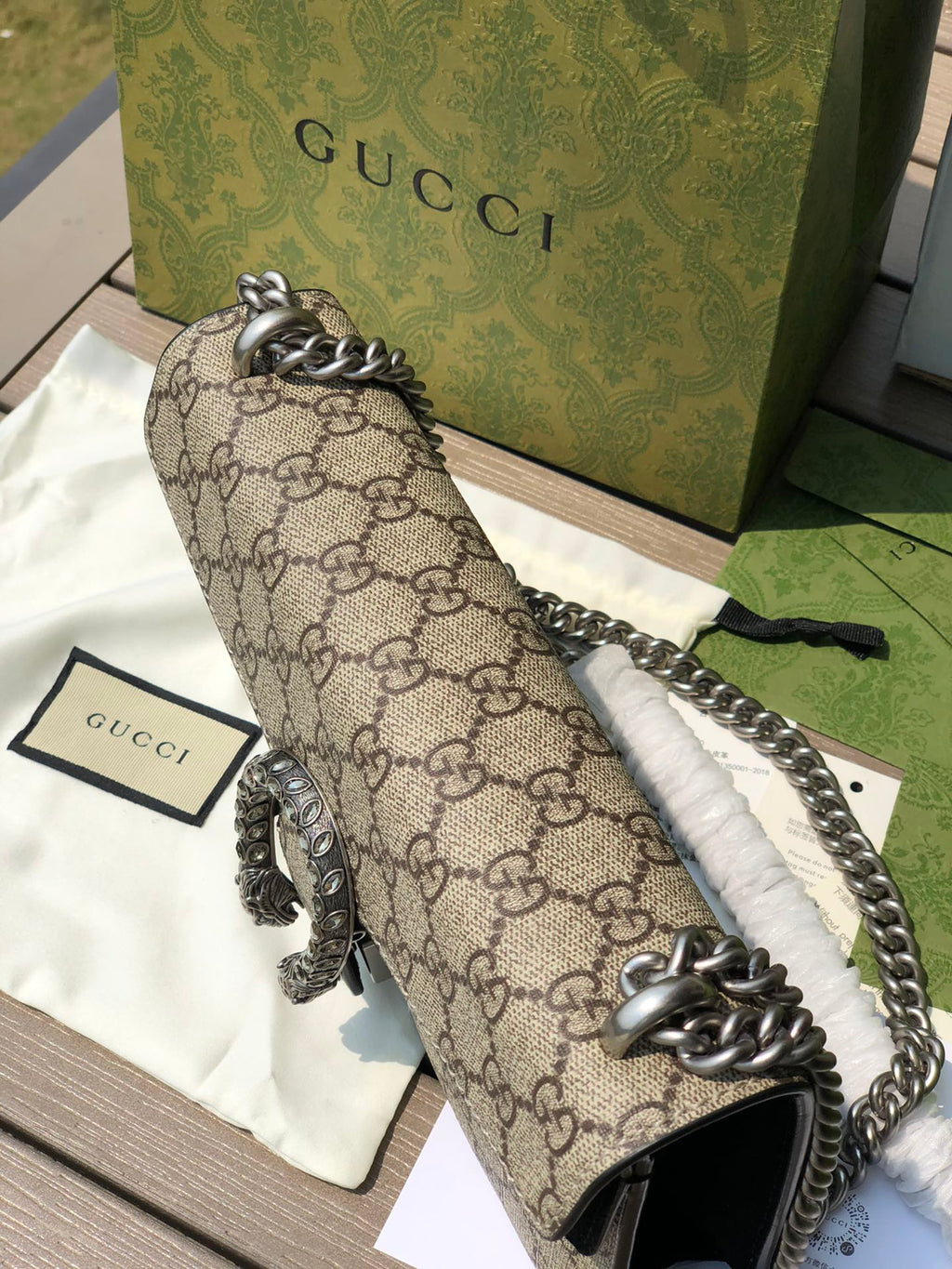 （571150898）尺寸：25×13.5×7cm GUCCI海外渠道資源特供酒神❗️這款Dionysus系列小號肩背包飾有經典GG Supreme帆布環保材料，雙G圖案和絨面材質滾邊細節。包上精心點綴品牌標誌性的飾水晶虎頭搭扣元素，其靈感源自希臘酒神狄俄尼索斯，在神話傳說中，他身騎宙斯派來的老虎跨越底格里斯河，閃亮水晶裝飾令搭扣更顯奢華氣息。滑動鍊帶打造多樣化的背法，可在肩背、斜背和手提之間自由轉換。