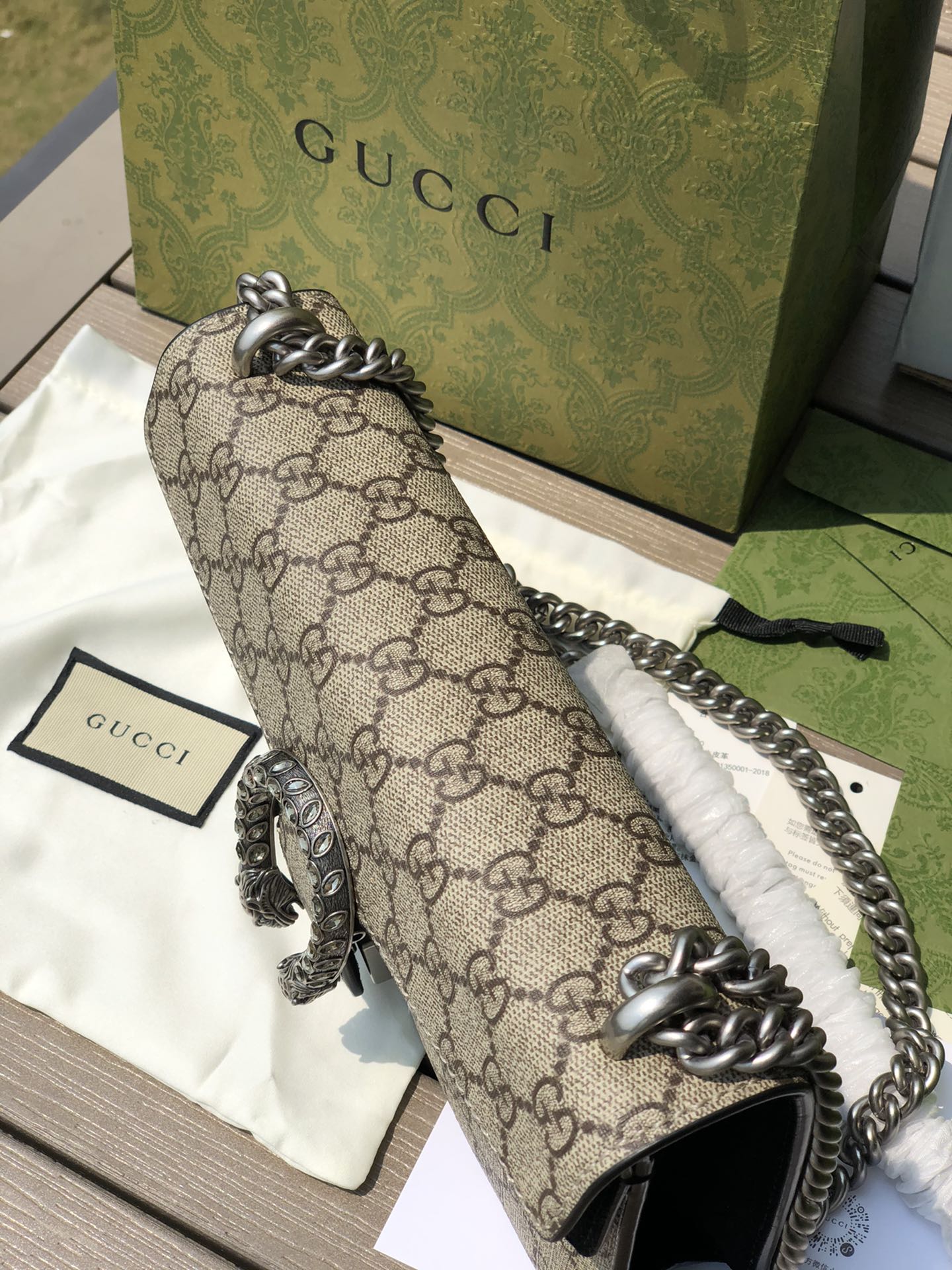 （571150898）尺寸：25×13.5×7cm GUCCI海外渠道資源特供酒神❗️這款Dionysus系列小號肩背包飾有經典GG Supreme帆布環保材料，雙G圖案和絨面材質滾邊細節。包上精心點綴品牌標誌性的飾水晶虎頭搭扣元素，其靈感源自希臘酒神狄俄尼索斯，在神話傳說中，他身騎宙斯派來的老虎跨越底格里斯河，閃亮水晶裝飾令搭扣更顯奢華氣息。滑動鍊帶打造多樣化的背法，可在肩背、斜背和手提之間自由轉換。