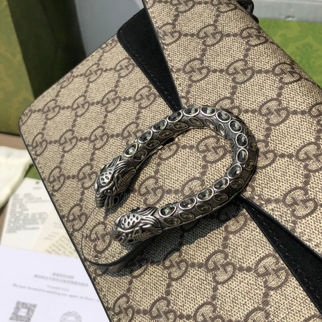 （571150898）尺寸：25×13.5×7cm GUCCI海外渠道資源特供酒神❗️這款Dionysus系列小號肩背包飾有經典GG Supreme帆布環保材料，雙G圖案和絨面材質滾邊細節。包上精心點綴品牌標誌性的飾水晶虎頭搭扣元素，其靈感源自希臘酒神狄俄尼索斯，在神話傳說中，他身騎宙斯派來的老虎跨越底格里斯河，閃亮水晶裝飾令搭扣更顯奢華氣息。滑動鍊帶打造多樣化的背法，可在肩背、斜背和手提之間自由轉換。