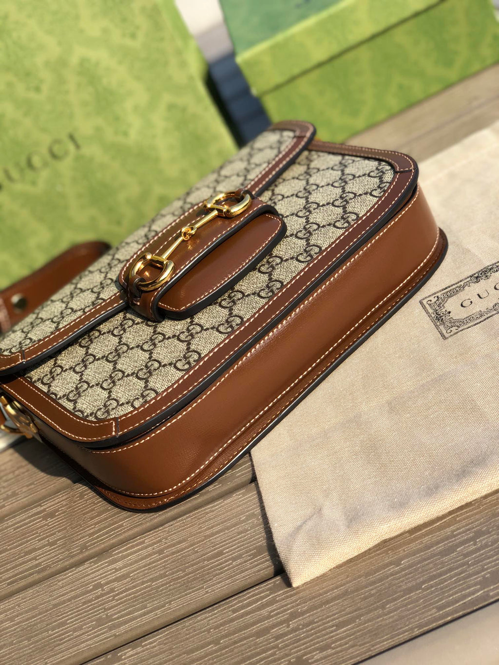 （861200898）尺寸：25×18×8cm  Gucci海外渠道资源特供1955系列马衔扣帆布单肩包❗️Gucci1955马衔扣手袋在2020早春系列中惊艳亮相，在复古当道的年代，这样一只包的岀现无疑能一眼击中人心，品牌标志性的经典元素，灵感源自马术中双环和链条的马衔扣再次出山1955的复古不仅体现在马蹄扣上，还有经典“双G”老花包身和做旧日的棕色皮革包边，所有设计运用到一起让包包充满70年代的摩登风格。同时配以可调节肩带，可在肩背和斜跨之间自由转换。