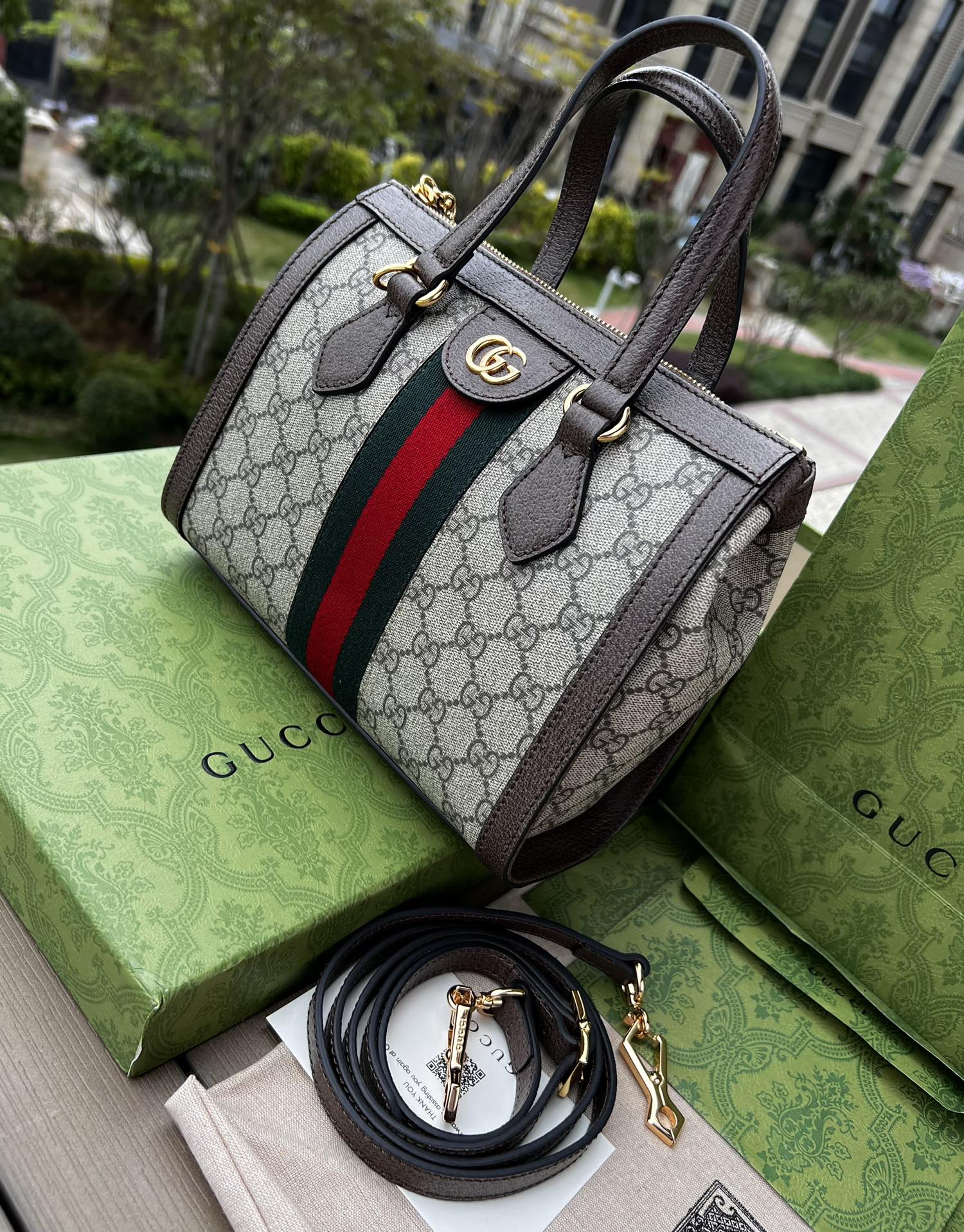 尺寸:24×20.5×10.5cm（561050898） Gucci通路訂單Ophidia 系列托特包❗️迎來新成員小號手提托特包，配上一條可拆卸肩帶。以GG Supreme 帆布製作，鑲嵌紅綠條紋織帶，小巧玲瓏的雙G圖案是源自於70年代的Gucci 典藏設計，裝飾包身的皮革飾片細節和拉鍊頭。閃亮金色金屬配件，內裡麂皮質感超細纖維襯裡