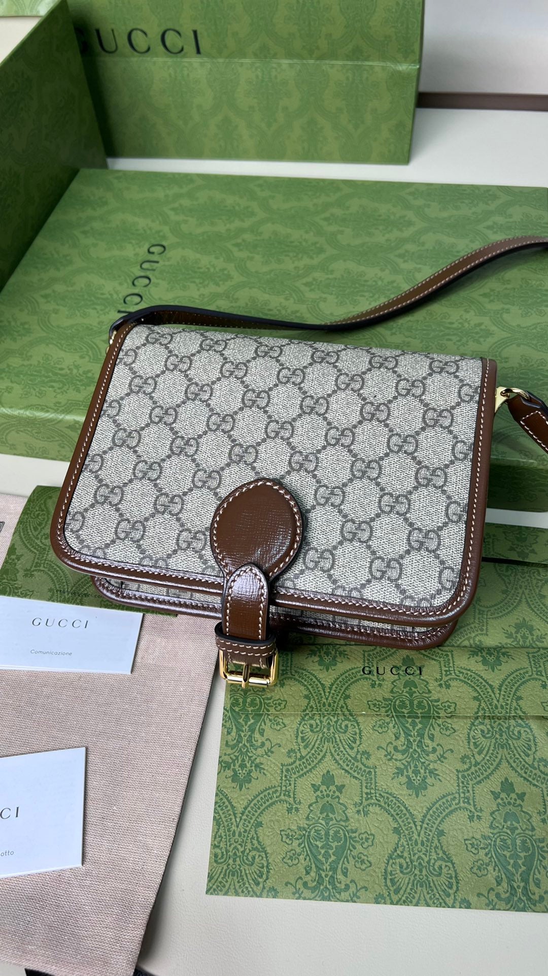 尺寸:20×17×8cm（26990898） Gucci海外通路資源特供男士郵差包❗️自問世以來，互扣式雙G一直都是品牌的標誌性元素之一。耳熟能詳的品牌象徵與皮革細節相融匯，讓這款單肩背包成為矚目的焦點。採用米色和烏木色GG Supreme 帆布，棕色皮革滾邊、棉麻襯裡，經典雙G字母交織帆布材質令整款設計散發出強烈的品牌內涵。