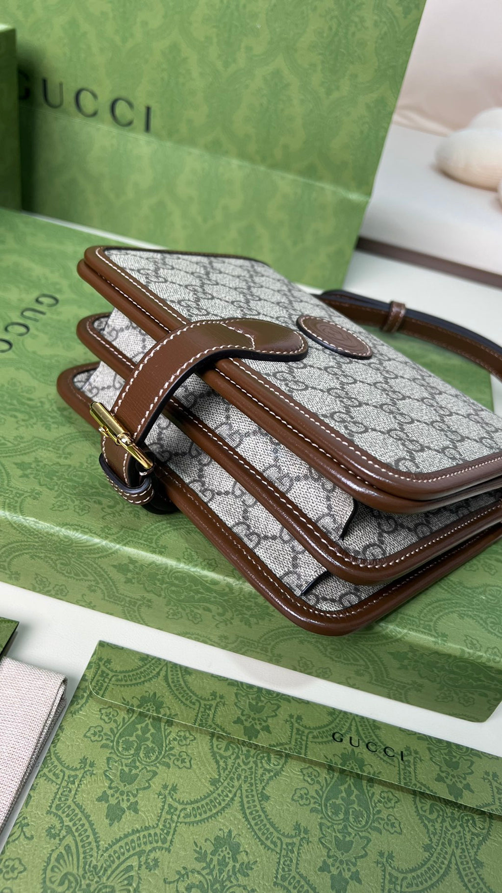 尺寸:20×17×8cm（26990898） Gucci海外通路資源特供男士郵差包❗️自問世以來，互扣式雙G一直都是品牌的標誌性元素之一。耳熟能詳的品牌象徵與皮革細節相融匯，讓這款單肩背包成為矚目的焦點。採用米色和烏木色GG Supreme 帆布，棕色皮革滾邊、棉麻襯裡，經典雙G字母交織帆布材質令整款設計散發出強烈的品牌內涵。