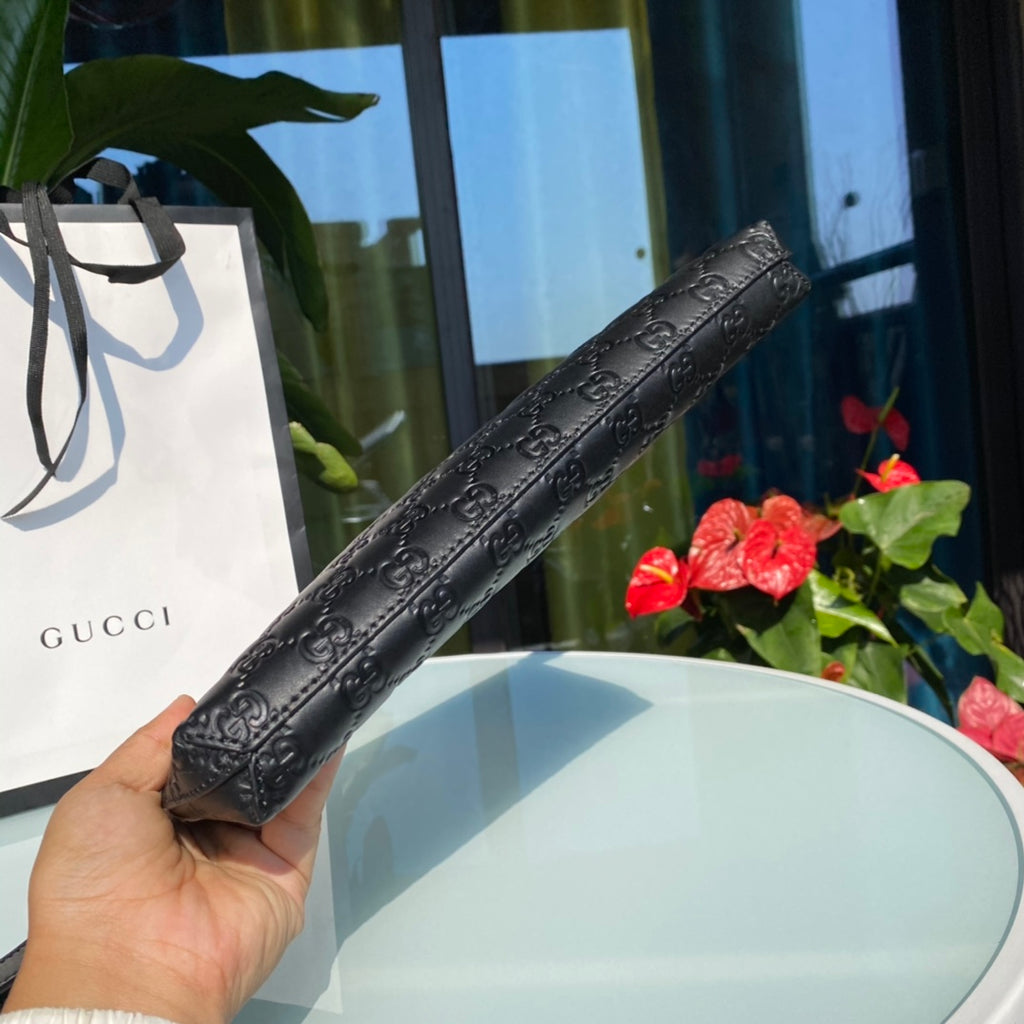 尺寸：30×23×4cm（04580898） Gucci海外渠道資源特供古馳薄款皮革手拿包，配有可拆卸提手，使用Gucci Signature軟皮製作，這是Gucci經典熱壓皮革的新版本，結構更具延展性。黑色Gucci Signature軟皮，搭配黑色皮革滾邊鈀色金屬配件、拉鍊內袋和智慧型手機袋、可拆卸皮革提手，灰色超細纖維襯裡，類似麂皮手感！