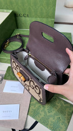 小號尺寸:21×15×7cm（781280898） Gucci海外渠道資源特供Bamboo1947飾雙G圖案竹節手袋❗️品牌標誌符號在每一季都會透過不同手法煥新演繹。 《Aria時尚詠嘆調》系列推出全新設計駝色和烏木色雙G圖案帆布，搭配棕色皮革滾邊，棉麻里襯，風格張揚奪目。這款小號手袋採用竹節提把設計，讓經典材質煥發出現代氣息。內裡帶1個帶鏡子，竹節手柄，搭配一條皮革肩帶➕一條織帶肩帶！多種風格切換