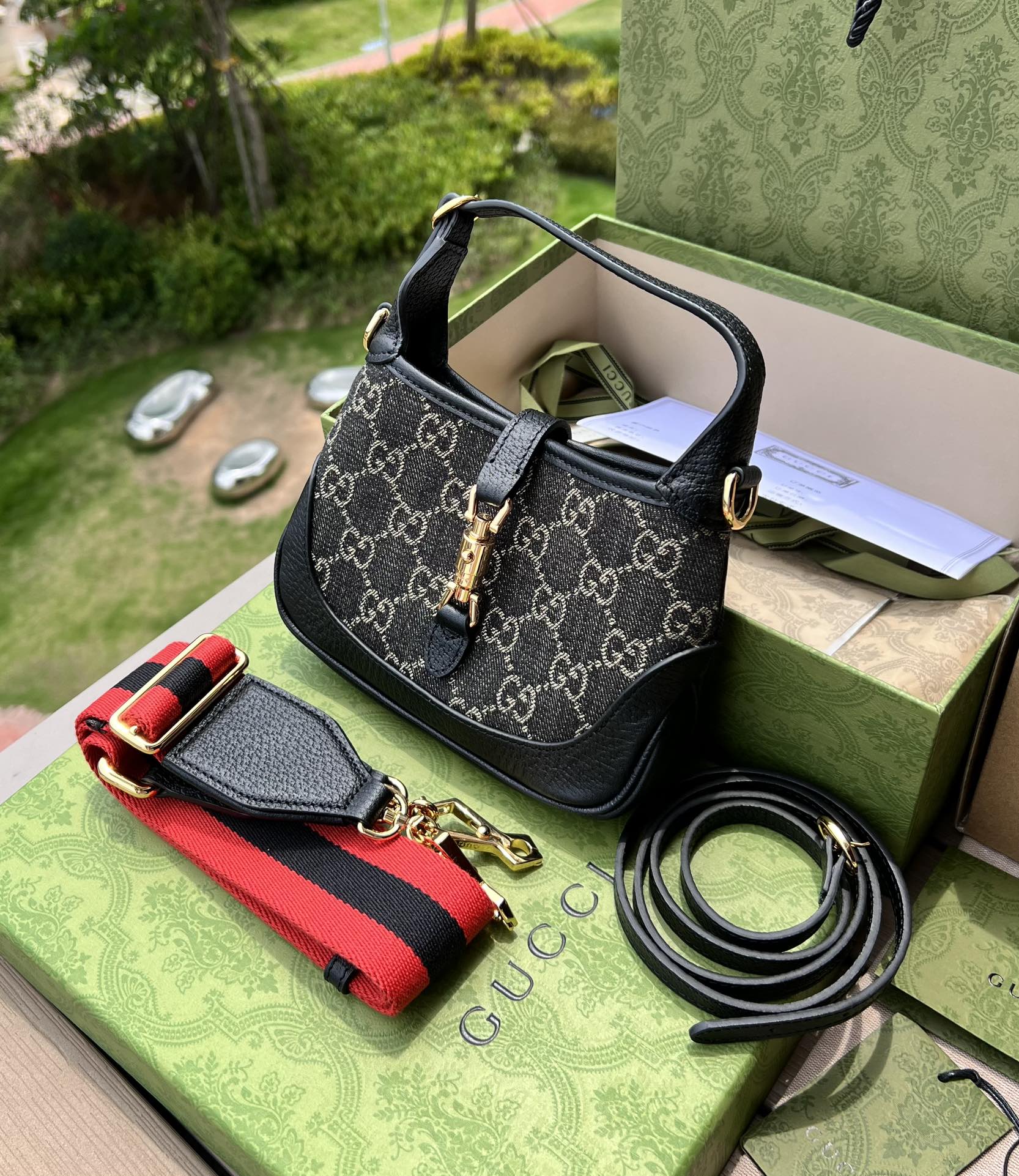 尺寸:19×13×3cm（561100898） Gucci海外通路資源特供Jackie1961系列迷你號❗️古馳《Aria時尚詠嘆調》系列運用現代手法煥新演繹經典元素。 Jackie 1961系列煥新推出質感柔軟、結構靈活的長方形托特包款。典藏設計搭配通體GG圖案和條紋織帶等標誌細節，精巧配件致敬Guccil 歷史傳承。這款小號手袋採用黑色皮革滾邊，搭配該系列標誌性的金色調推入式鎖扣配件。