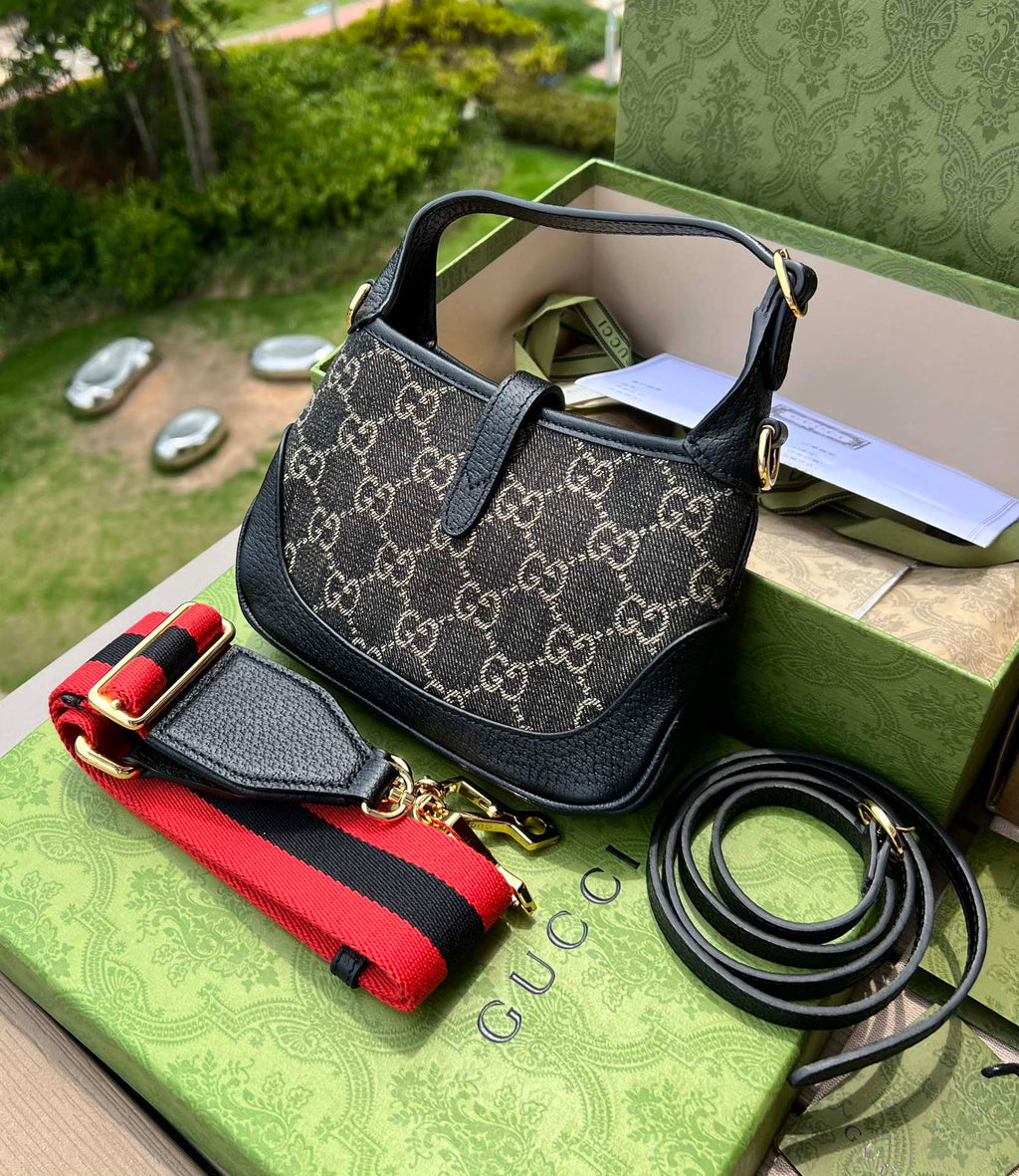 尺寸:19×13×3cm（561100898） Gucci海外通路資源特供Jackie1961系列迷你號❗️古馳《Aria時尚詠嘆調》系列運用現代手法煥新演繹經典元素。 Jackie 1961系列煥新推出質感柔軟、結構靈活的長方形托特包款。典藏設計搭配通體GG圖案和條紋織帶等標誌細節，精巧配件致敬Guccil 歷史傳承。這款小號手袋採用黑色皮革滾邊，搭配該系列標誌性的金色調推入式鎖扣配件。