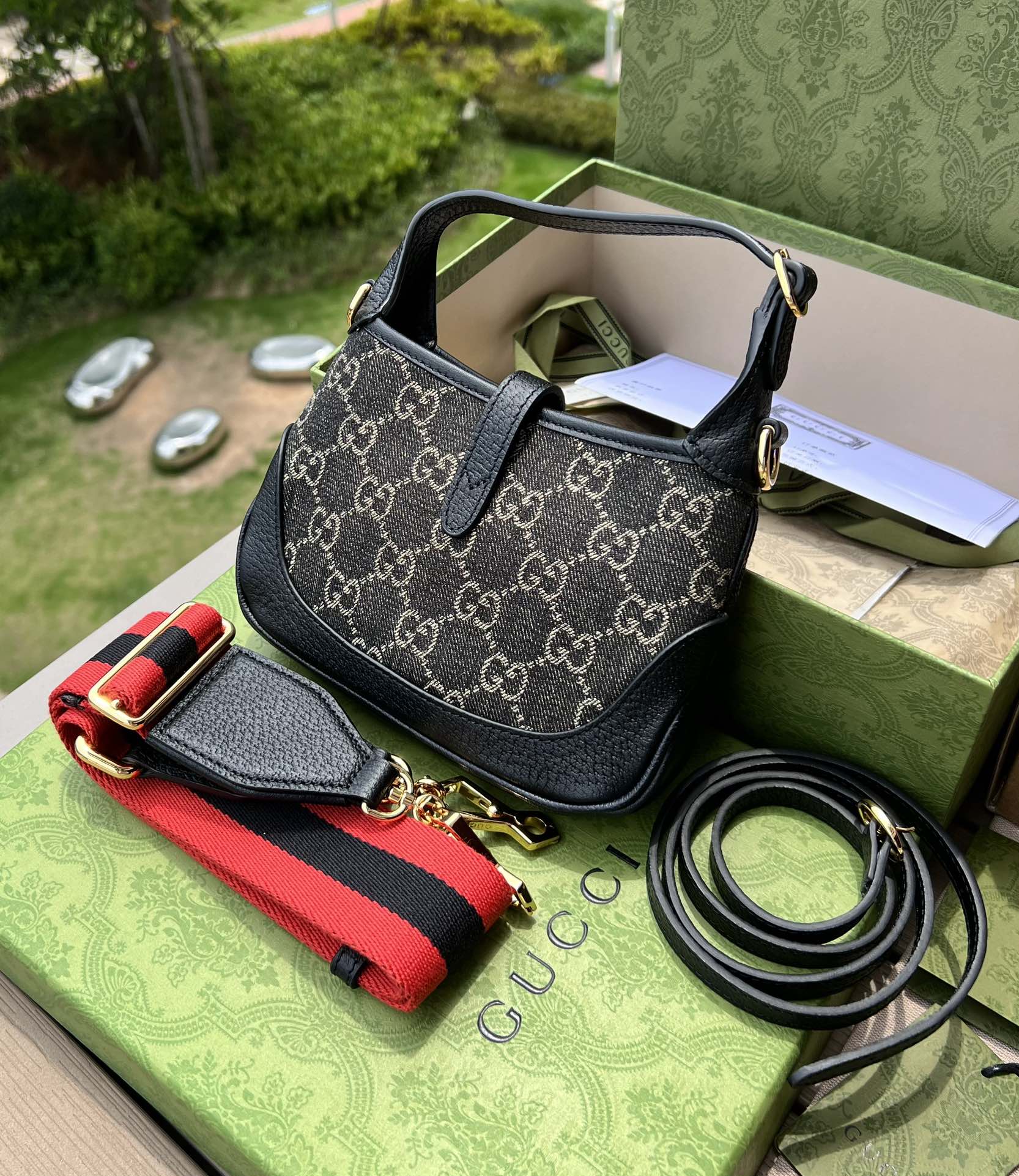 尺寸:19×13×3cm（561100898） Gucci海外通路資源特供Jackie1961系列迷你號❗️古馳《Aria時尚詠嘆調》系列運用現代手法煥新演繹經典元素。 Jackie 1961系列煥新推出質感柔軟、結構靈活的長方形托特包款。典藏設計搭配通體GG圖案和條紋織帶等標誌細節，精巧配件致敬Guccil 歷史傳承。這款小號手袋採用黑色皮革滾邊，搭配該系列標誌性的金色調推入式鎖扣配件。