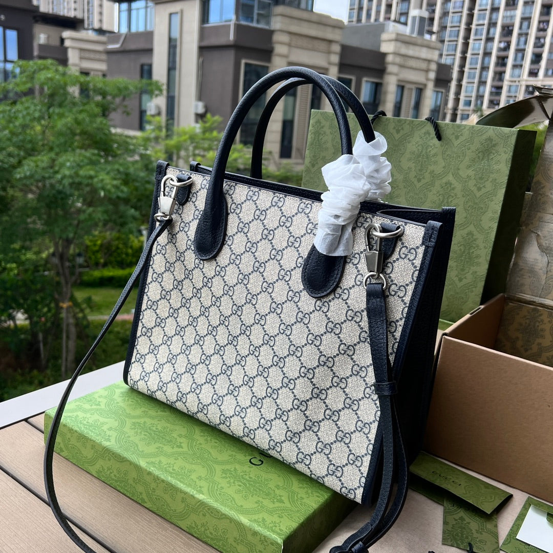 尺寸:31×26.5×14cm（071090898） Gucci海外通路資源特供托特包❗️在《古馳愛的進行曲》全新時裝系列中，品牌推出了藍色和米色的GG Supreme 帆布組合，經典雋永，傳承品牌經典材質的歷史淵源。對於環境的影響較低的帆布材質被長久地運用於多個系列當中，已成為品牌的標誌性材質。這款小號互扣式雙G托特包採用經典配色環保材質，以藍色皮革滾邊，可手提肩背，長肩帶可拆卸可調節