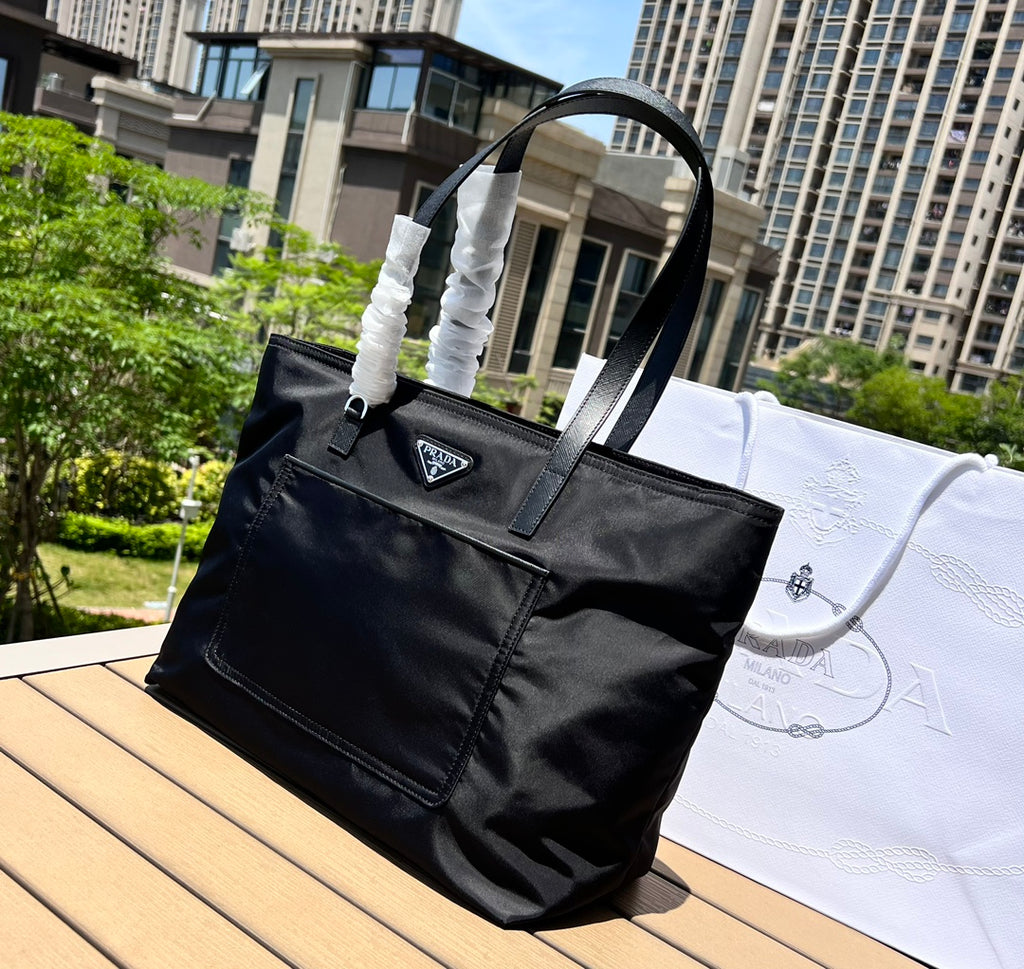 尺寸:35×30×14cm（05780898） PRADA通路資源特供降落傘布製作❗️Re-Nylon 再生尼龍購物袋，Re-Nylon 再生尼龍透過提純海洋塑膠、漁網和紡織纖維回收物製成，闡釋創新理念。包身正面配有前貼袋，拉鍊開合，飾以塗琺瑯金屬三角形徽標，當媽咪袋也是不錯的選擇