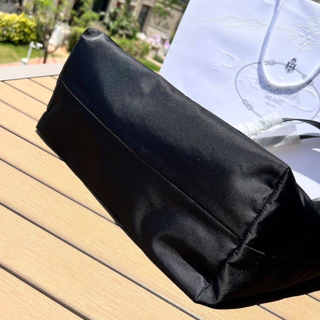 尺寸:35×30×14cm（05780898） PRADA通路資源特供降落傘布製作❗️Re-Nylon 再生尼龍購物袋，Re-Nylon 再生尼龍透過提純海洋塑膠、漁網和紡織纖維回收物製成，闡釋創新理念。包身正面配有前貼袋，拉鍊開合，飾以塗琺瑯金屬三角形徽標，當媽咪袋也是不錯的選擇