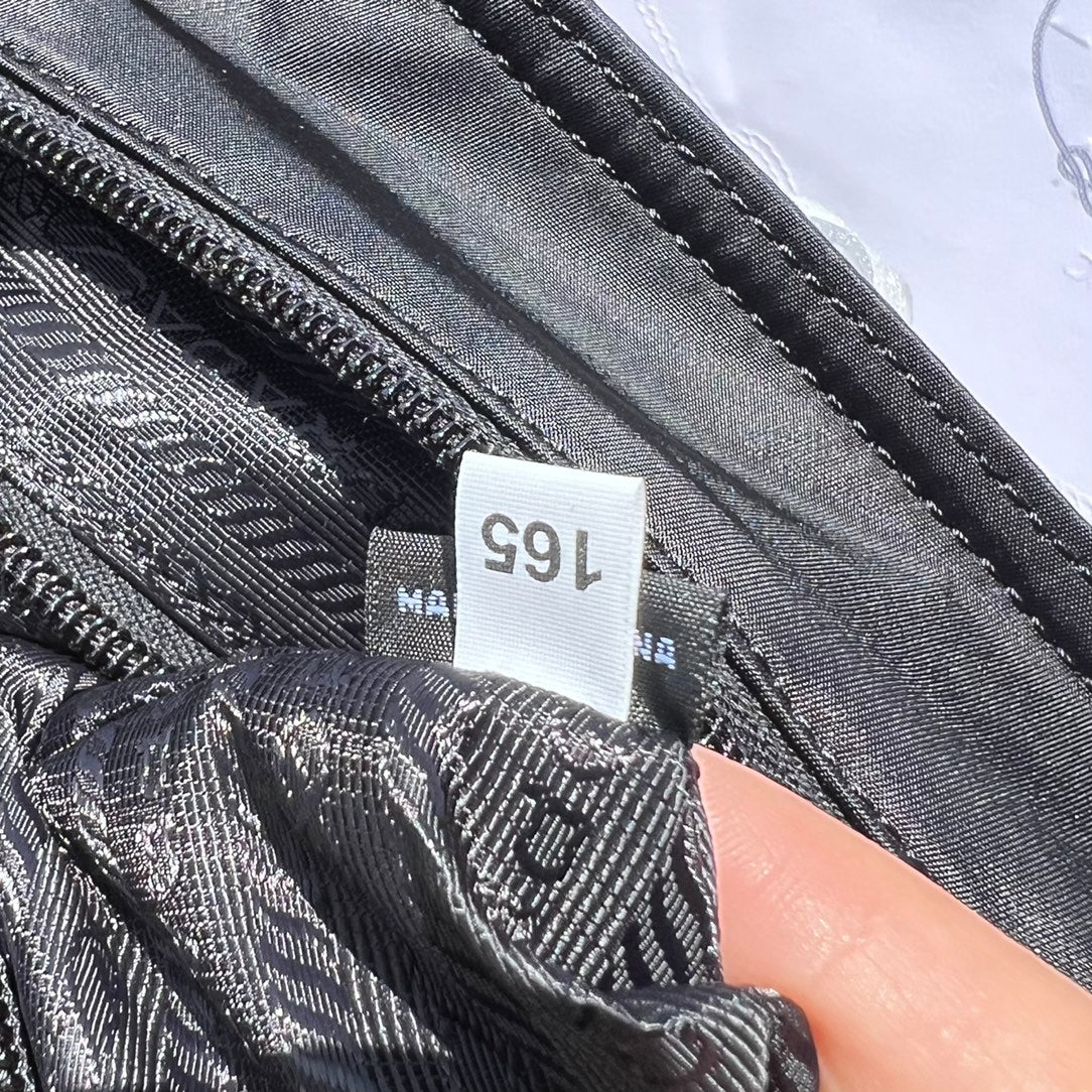 尺寸:35×30×14cm（05780898） PRADA通路資源特供降落傘布製作❗️Re-Nylon 再生尼龍購物袋，Re-Nylon 再生尼龍透過提純海洋塑膠、漁網和紡織纖維回收物製成，闡釋創新理念。包身正面配有前貼袋，拉鍊開合，飾以塗琺瑯金屬三角形徽標，當媽咪袋也是不錯的選擇