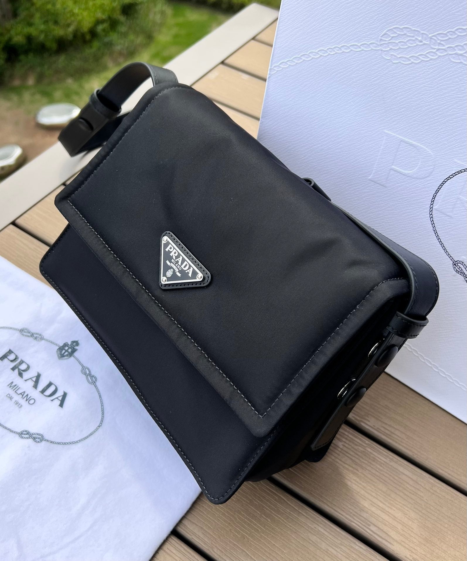 尺寸:23×16×11cm（05800898） PRADA通路資源特供訂單尼龍郵差包❗️混搭理念貫穿於Pradal 的敘事語言中，藉由材質、廓形和功能之間別樣的趣味組合，詮釋出充滿創意的設計。這款翻蓋式單肩包經海洋塑膠回收物所製的Re-Nylon 再生尼龍科技創新材質重釋，呈現精緻的柔美廓形。加襯工藝賦予包身柔和現代的外觀，正面飾有塗琺瑯三角標，磁扣開合，背面拉鍊式貼袋，可調式皮革肩帶便於多種方式攜帶。