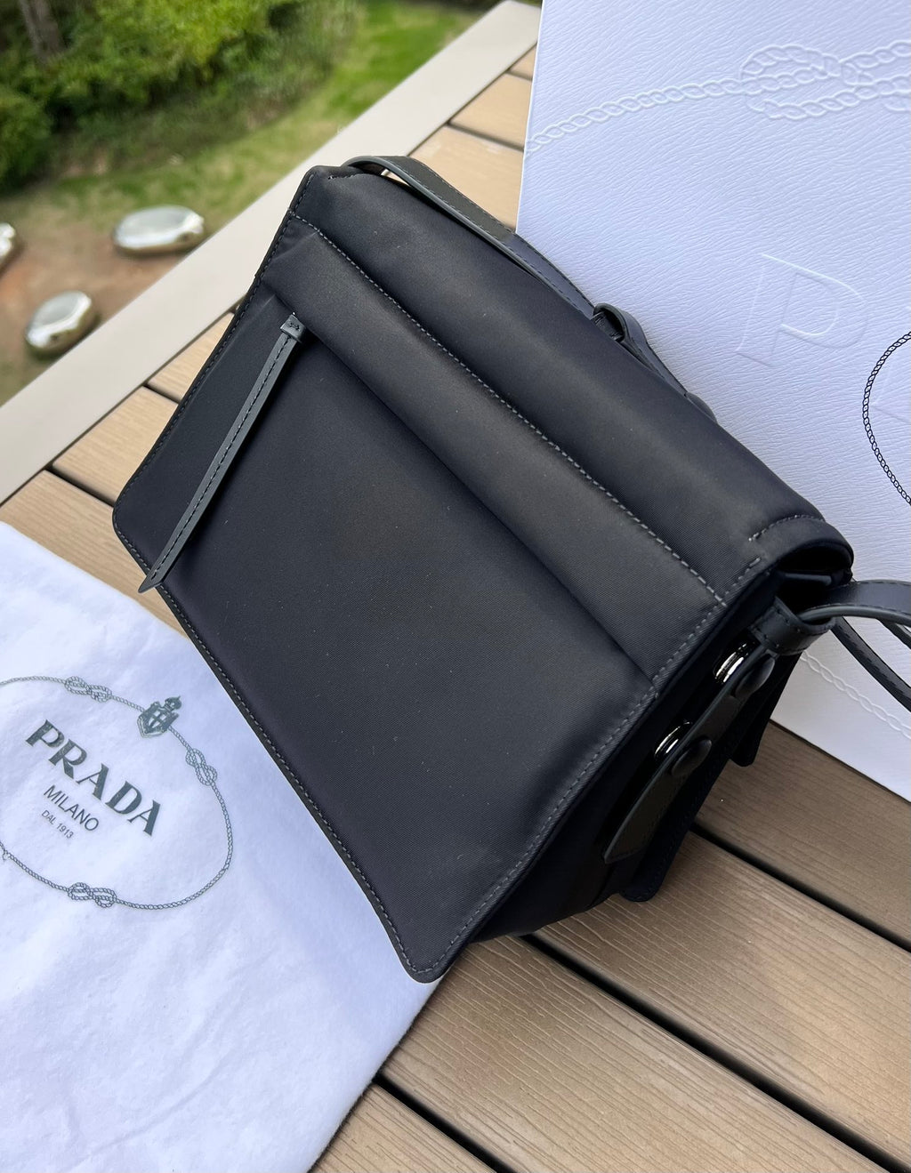 尺寸:23×16×11cm（05800898） PRADA通路資源特供訂單尼龍郵差包❗️混搭理念貫穿於Pradal 的敘事語言中，藉由材質、廓形和功能之間別樣的趣味組合，詮釋出充滿創意的設計。這款翻蓋式單肩包經海洋塑膠回收物所製的Re-Nylon 再生尼龍科技創新材質重釋，呈現精緻的柔美廓形。加襯工藝賦予包身柔和現代的外觀，正面飾有塗琺瑯三角標，磁扣開合，背面拉鍊式貼袋，可調式皮革肩帶便於多種方式攜帶。