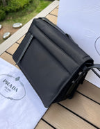 尺寸:23×16×11cm（05800898） PRADA通路資源特供訂單尼龍郵差包❗️混搭理念貫穿於Pradal 的敘事語言中，藉由材質、廓形和功能之間別樣的趣味組合，詮釋出充滿創意的設計。這款翻蓋式單肩包經海洋塑膠回收物所製的Re-Nylon 再生尼龍科技創新材質重釋，呈現精緻的柔美廓形。加襯工藝賦予包身柔和現代的外觀，正面飾有塗琺瑯三角標，磁扣開合，背面拉鍊式貼袋，可調式皮革肩帶便於多種方式攜帶。