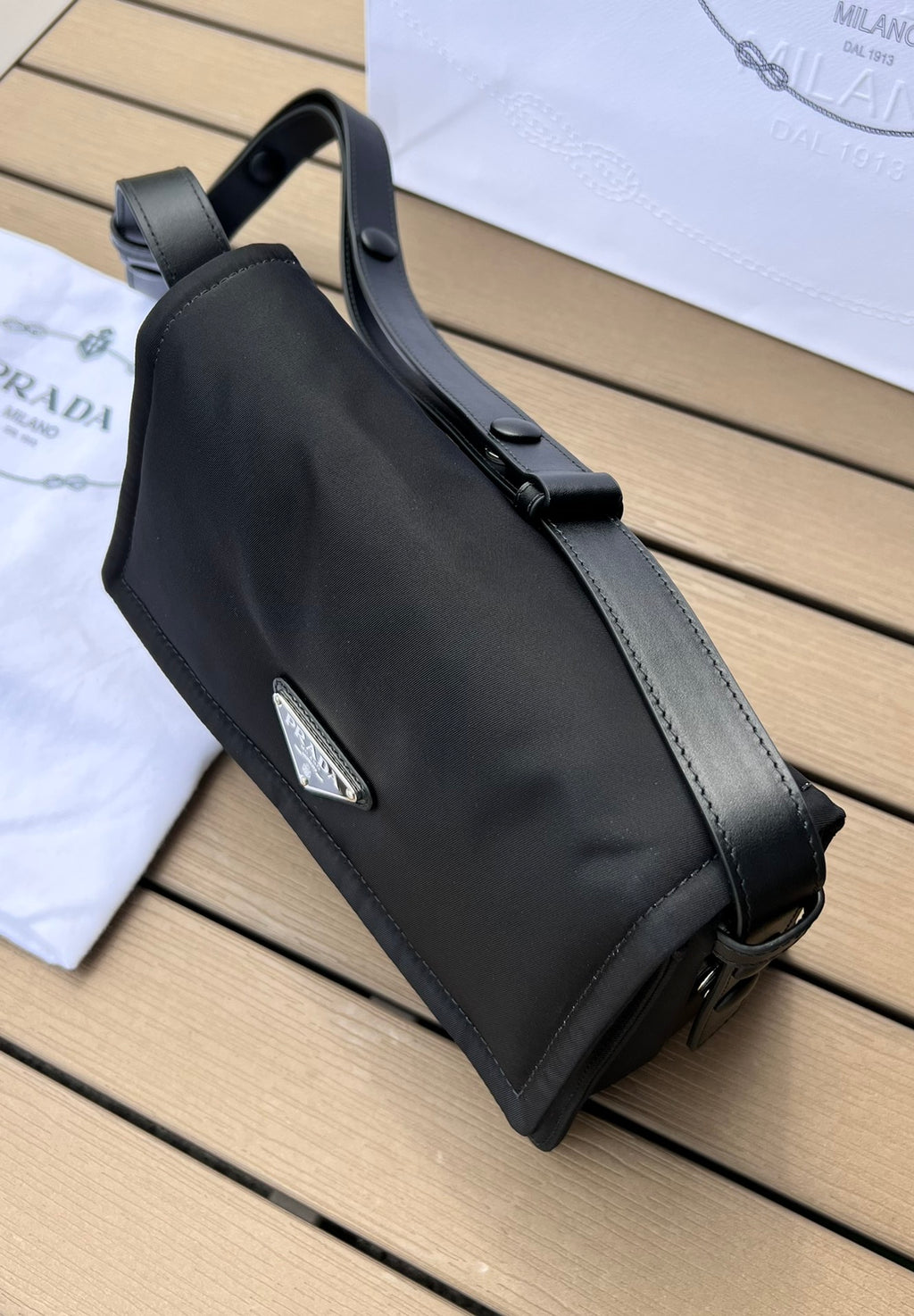 尺寸:23×16×11cm（05800898） PRADA通路資源特供訂單尼龍郵差包❗️混搭理念貫穿於Pradal 的敘事語言中，藉由材質、廓形和功能之間別樣的趣味組合，詮釋出充滿創意的設計。這款翻蓋式單肩包經海洋塑膠回收物所製的Re-Nylon 再生尼龍科技創新材質重釋，呈現精緻的柔美廓形。加襯工藝賦予包身柔和現代的外觀，正面飾有塗琺瑯三角標，磁扣開合，背面拉鍊式貼袋，可調式皮革肩帶便於多種方式攜帶。