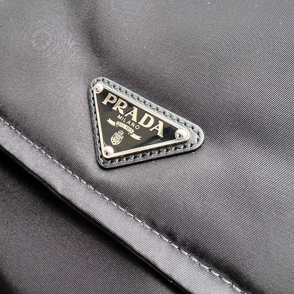 尺寸:23×16×11cm（05800898） PRADA通路資源特供訂單尼龍郵差包❗️混搭理念貫穿於Pradal 的敘事語言中，藉由材質、廓形和功能之間別樣的趣味組合，詮釋出充滿創意的設計。這款翻蓋式單肩包經海洋塑膠回收物所製的Re-Nylon 再生尼龍科技創新材質重釋，呈現精緻的柔美廓形。加襯工藝賦予包身柔和現代的外觀，正面飾有塗琺瑯三角標，磁扣開合，背面拉鍊式貼袋，可調式皮革肩帶便於多種方式攜帶。