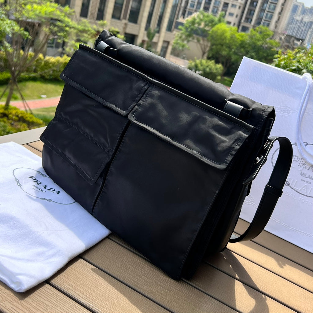 大尺寸:36×28×14cm（091250898） PRADA通路資源特供尼龍郵差包❗️選用Re-Nylon 再生尼龍材質打造。永續材質的應用象徵Prada 在布料的演進。翻蓋式包身配有可調式皮革肩帶，傳統與現代材質邂逅，造就都會優雅風格。背部拉鍊式口袋設計獨特功能性，翻蓋處飾以塗琺瑯金屬三角形徽標，鮮明醒目。磁扣式翻蓋開合，Re-Nylon 再生尼龍襯裡，配兩個口袋，其中一個帶拉鍊，極具有功能性和滿滿設計感