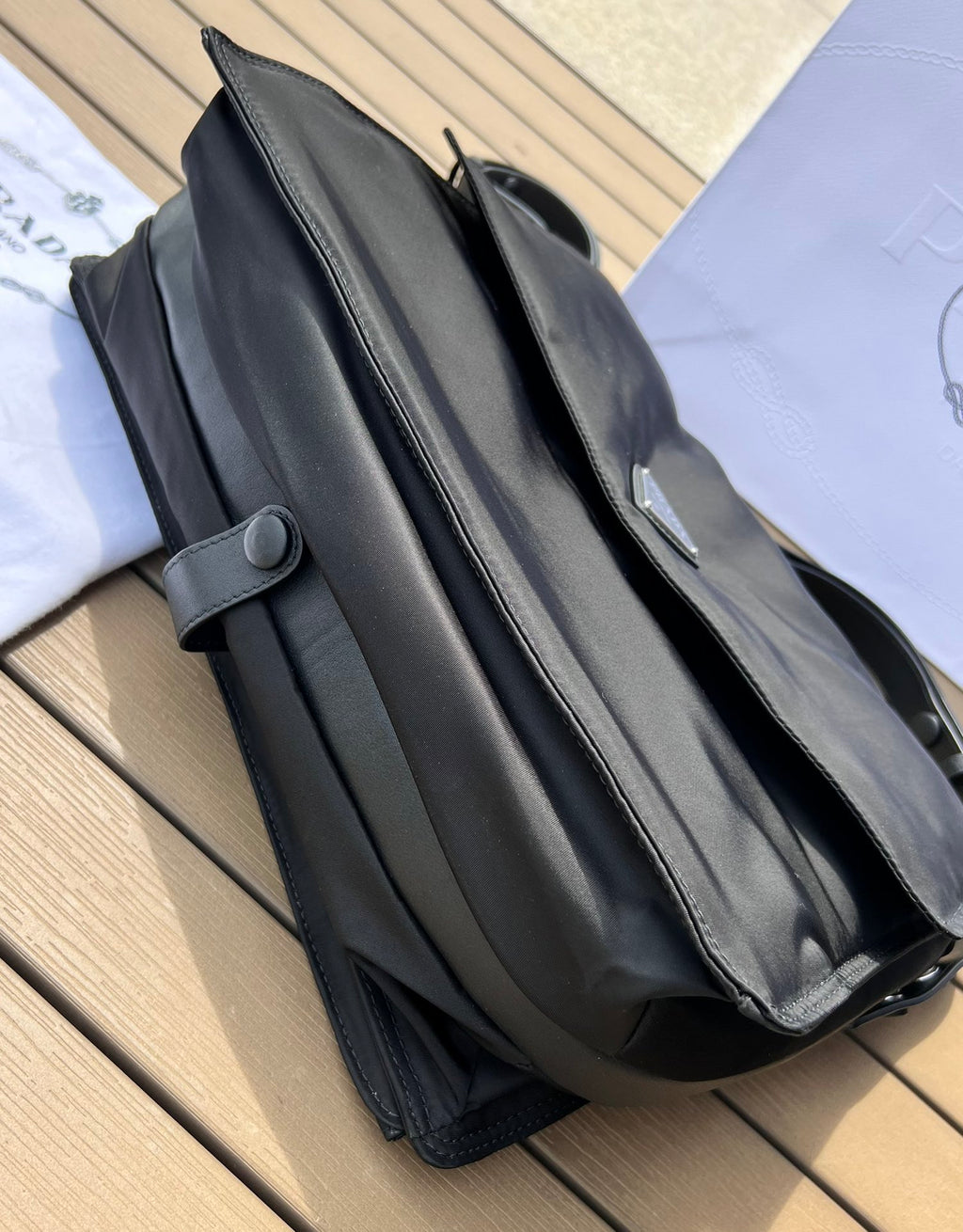 大尺寸:36×28×14cm（091250898） PRADA通路資源特供尼龍郵差包❗️選用Re-Nylon 再生尼龍材質打造。永續材質的應用象徵Prada 在布料的演進。翻蓋式包身配有可調式皮革肩帶，傳統與現代材質邂逅，造就都會優雅風格。背部拉鍊式口袋設計獨特功能性，翻蓋處飾以塗琺瑯金屬三角形徽標，鮮明醒目。磁扣式翻蓋開合，Re-Nylon 再生尼龍襯裡，配兩個口袋，其中一個帶拉鍊，極具有功能性和滿滿設計感