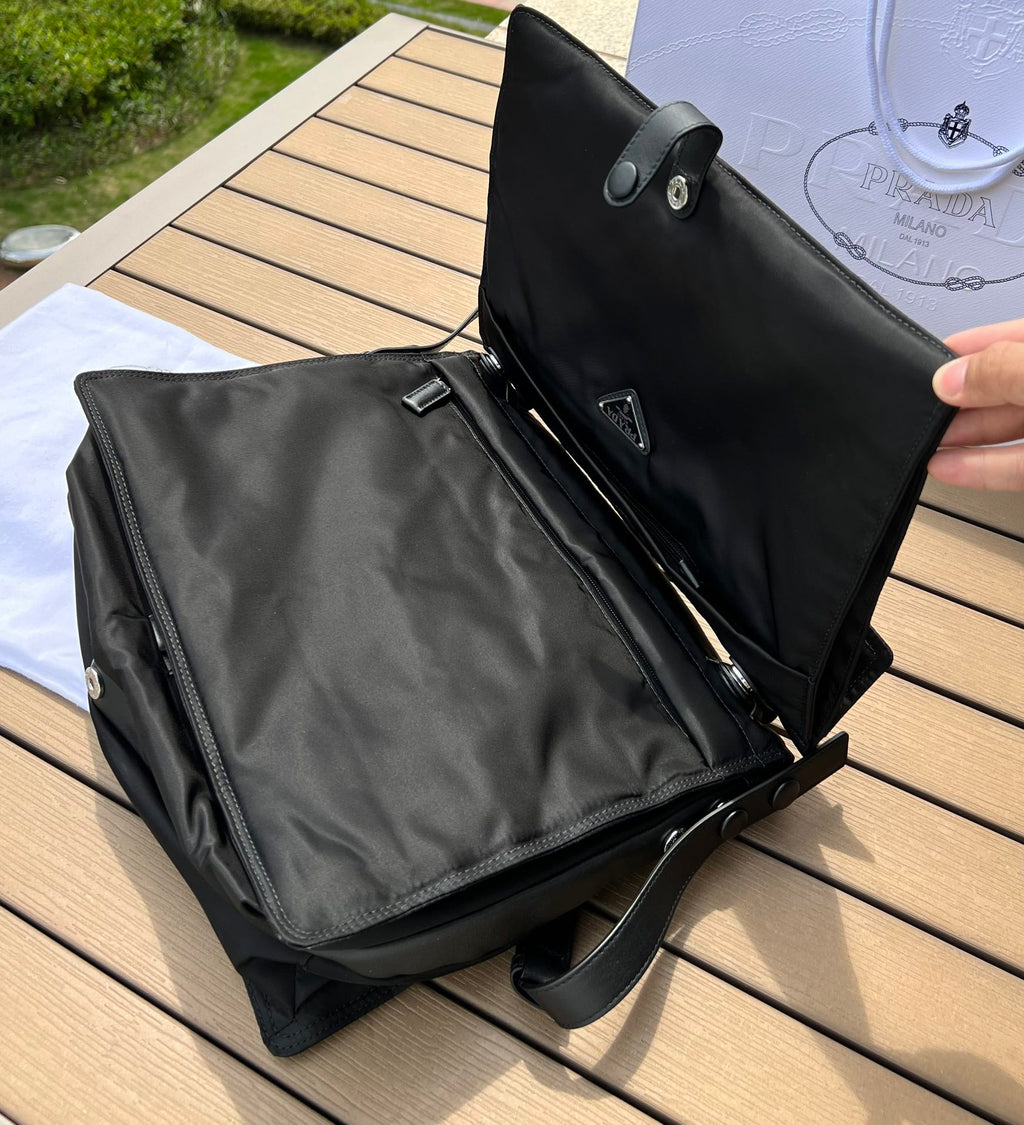 大尺寸:36×28×14cm（091250898） PRADA通路資源特供尼龍郵差包❗️選用Re-Nylon 再生尼龍材質打造。永續材質的應用象徵Prada 在布料的演進。翻蓋式包身配有可調式皮革肩帶，傳統與現代材質邂逅，造就都會優雅風格。背部拉鍊式口袋設計獨特功能性，翻蓋處飾以塗琺瑯金屬三角形徽標，鮮明醒目。磁扣式翻蓋開合，Re-Nylon 再生尼龍襯裡，配兩個口袋，其中一個帶拉鍊，極具有功能性和滿滿設計感