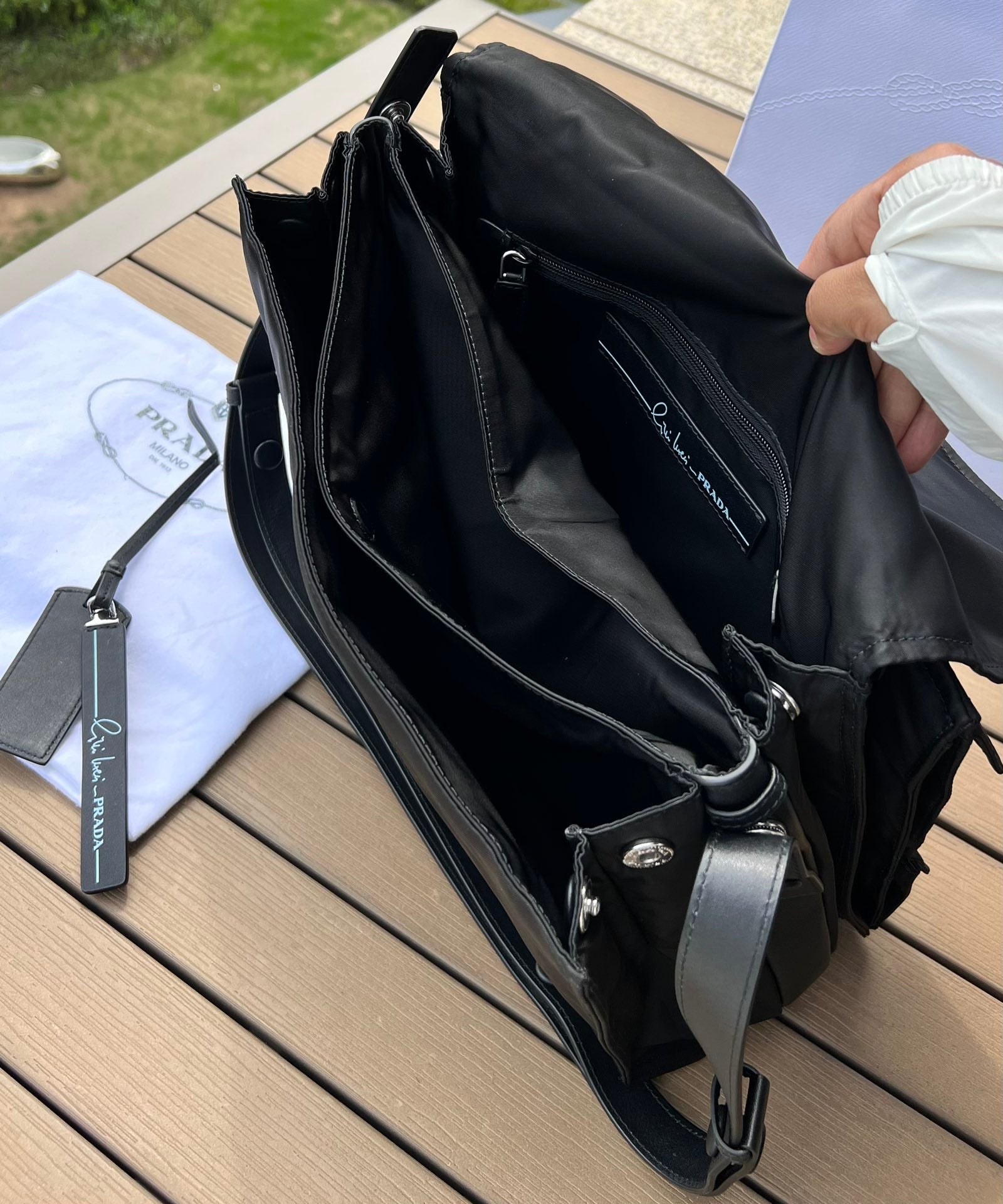 大尺寸:36×28×14cm（091250898） PRADA通路資源特供尼龍郵差包❗️選用Re-Nylon 再生尼龍材質打造。永續材質的應用象徵Prada 在布料的演進。翻蓋式包身配有可調式皮革肩帶，傳統與現代材質邂逅，造就都會優雅風格。背部拉鍊式口袋設計獨特功能性，翻蓋處飾以塗琺瑯金屬三角形徽標，鮮明醒目。磁扣式翻蓋開合，Re-Nylon 再生尼龍襯裡，配兩個口袋，其中一個帶拉鍊，極具有功能性和滿滿設計感