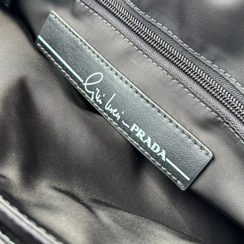 大尺寸:36×28×14cm（091250898） PRADA通路資源特供尼龍郵差包❗️選用Re-Nylon 再生尼龍材質打造。永續材質的應用象徵Prada 在布料的演進。翻蓋式包身配有可調式皮革肩帶，傳統與現代材質邂逅，造就都會優雅風格。背部拉鍊式口袋設計獨特功能性，翻蓋處飾以塗琺瑯金屬三角形徽標，鮮明醒目。磁扣式翻蓋開合，Re-Nylon 再生尼龍襯裡，配兩個口袋，其中一個帶拉鍊，極具有功能性和滿滿設計感