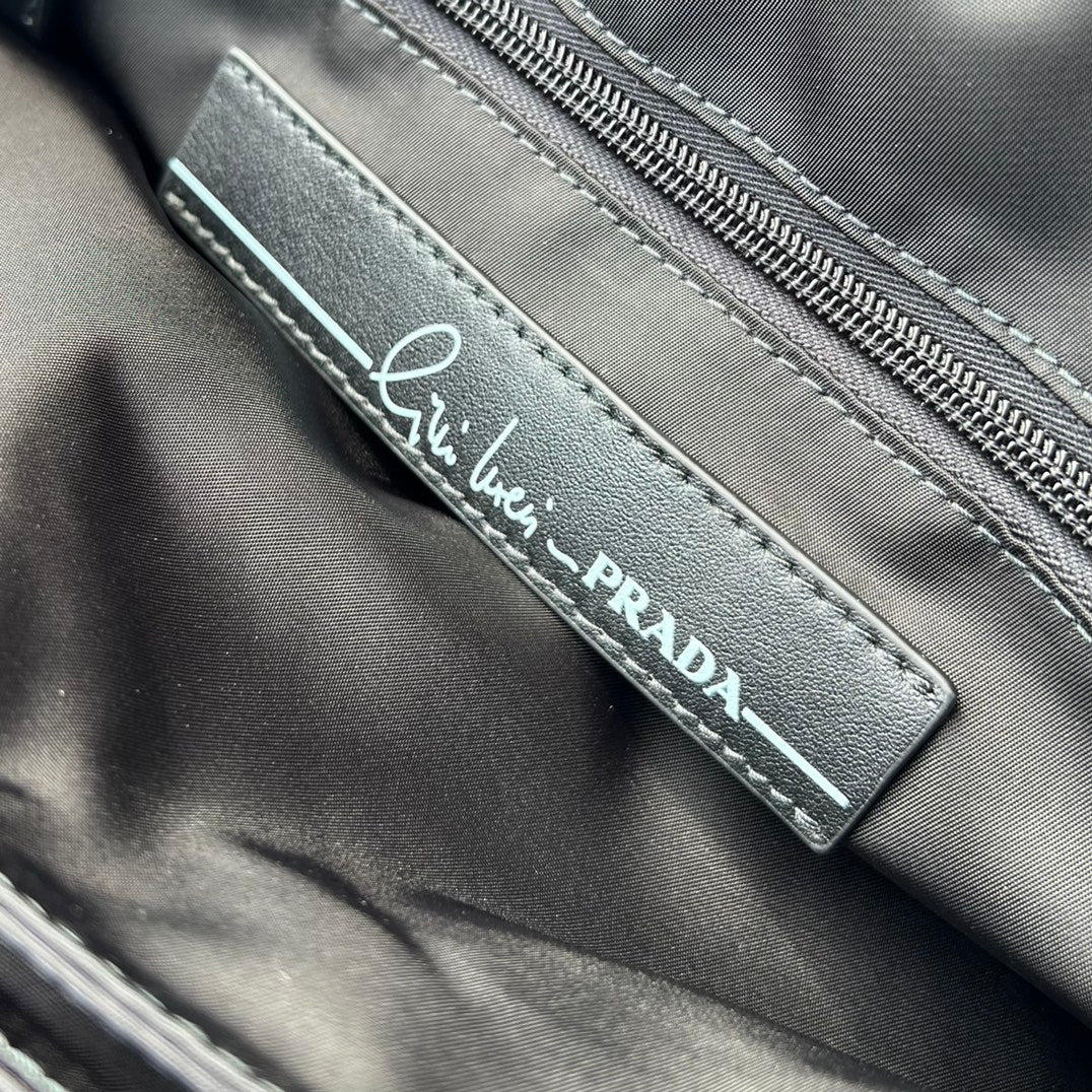 大尺寸:36×28×14cm（091250898） PRADA通路資源特供尼龍郵差包❗️選用Re-Nylon 再生尼龍材質打造。永續材質的應用象徵Prada 在布料的演進。翻蓋式包身配有可調式皮革肩帶，傳統與現代材質邂逅，造就都會優雅風格。背部拉鍊式口袋設計獨特功能性，翻蓋處飾以塗琺瑯金屬三角形徽標，鮮明醒目。磁扣式翻蓋開合，Re-Nylon 再生尼龍襯裡，配兩個口袋，其中一個帶拉鍊，極具有功能性和滿滿設計感