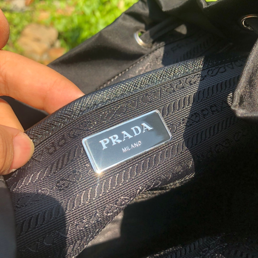 代工廠通路貨！新款背包，尺寸：32×30×15cm （571050898）Prada新款尼龍雙肩包！ 100%代工廠渠道。原廠防水耐磨的空軍專用降落傘布料！原廠布料看起來都不一樣，質感很舒服！如果是市場一般貨會有一個最明顯的缺點，就是布料偏薄或偏硬！而我們在賣的版本說是全市場第一當之無愧！因為這個貨才是真正代工廠出品！